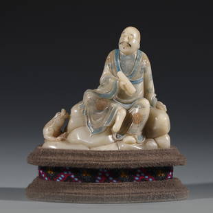 SHOUSHAN STONE CARVED ARHAT ON STAND: Dimensions: Length: 10.3cm, Width: 4.2cm, Height: 10.5 cm, Weigth: 375g Chinese Qing Dynasty Shoushan Stone Arhat Buddha On Fitted Cushion Hardwood Stand. This Porcelain statue of Buddha is perfect