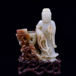 CARVED JADE GUANYIN FIGURE ON STAND: Dimensions: 149.25mm H x 111.92mm WWeight:965.7g Stand: 1-5/8" H Exceptional Chinese Jade standing Guanyin figure. Dressed in a traditional diaphanous robe, with left hand raised to chest level