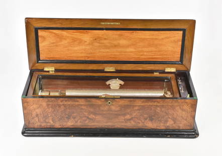 GEORGE BAKER SWISS MUSIC BOX, GENEVA: in working condition. Excellent Flame Mahogany Case 33" with minor nicks to casing. The works are pristine and plays loud and in tune. Dimension: 33" L