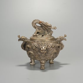 A SILVER INCENSE BURNER WITH DRAGON PATTERNS
