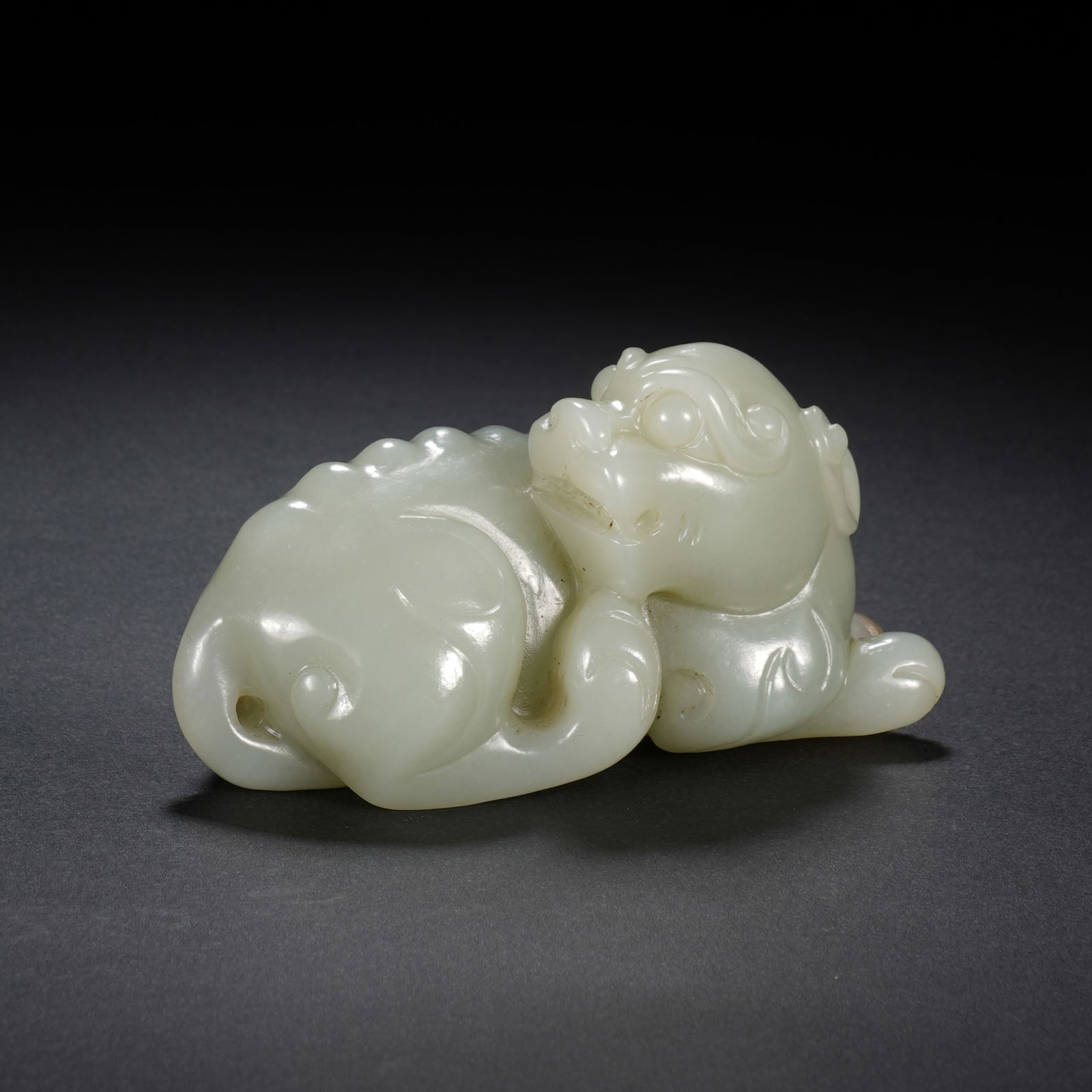 Chinese Hetian Jade Auspicious Beast Paperweight: Dimensions: 8.5x4x4.5 cm. Weight 177 grams. This Chinese Hetian white jade auspicious beast paperweight (8.5 x 4 x 4.5 cm; 177 grams) is crafted from luminous, creamy Hetian jade. Carved into a reclin