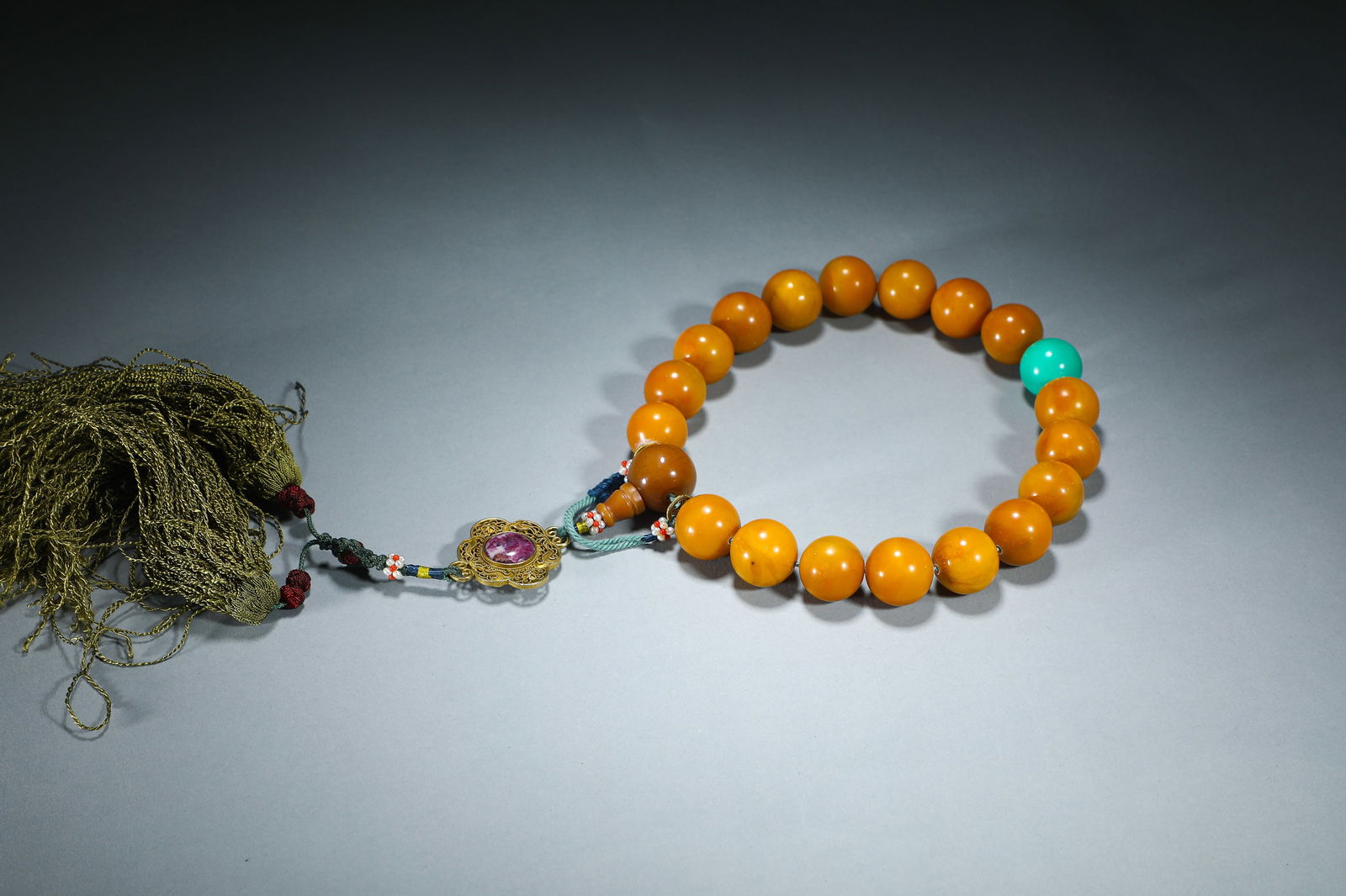 CHINESE TIANHUANG 18-BEAD PRAYER BRACELET: Dimensions: Bead diam. 2 cm. This distinguished Chinese 18-bead prayer bracelet is crafted from warm, honey-toned tianhuang stone beads, each measuring 2 cm in diameter. It features a vibrant turquois