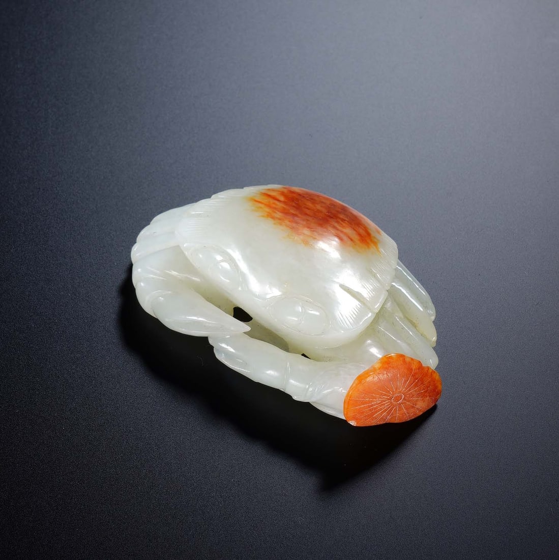 CHINESE WHITE JADE CRAB TOGGLE: Dimensions: 7.5x4.7x2 cm. Weight 99 grams. This exquisite Chinese white jade toggle is carved in the form of a crab, skillfully utilizing natural russet skin for the carapace and a lotus leaf