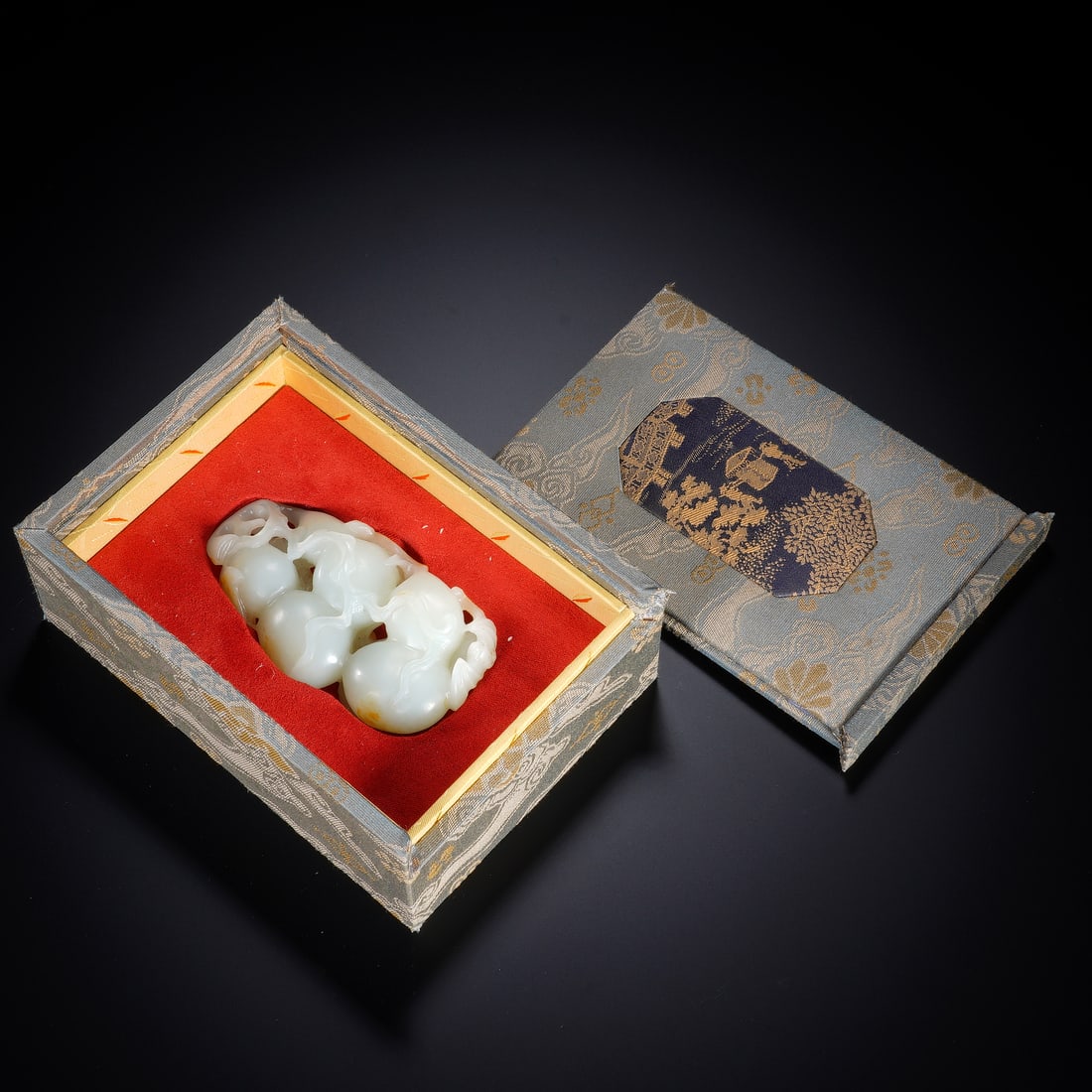 CHINESE WHITE JADE PEACH GROUP: Dimensions: 8.5x2.5x5 cm. Weight 113 grams. A delicate Chinese white jade carving of a cluster of peaches, rendered in translucent white jade with a subtle russet inclusion. The fruit is naturally