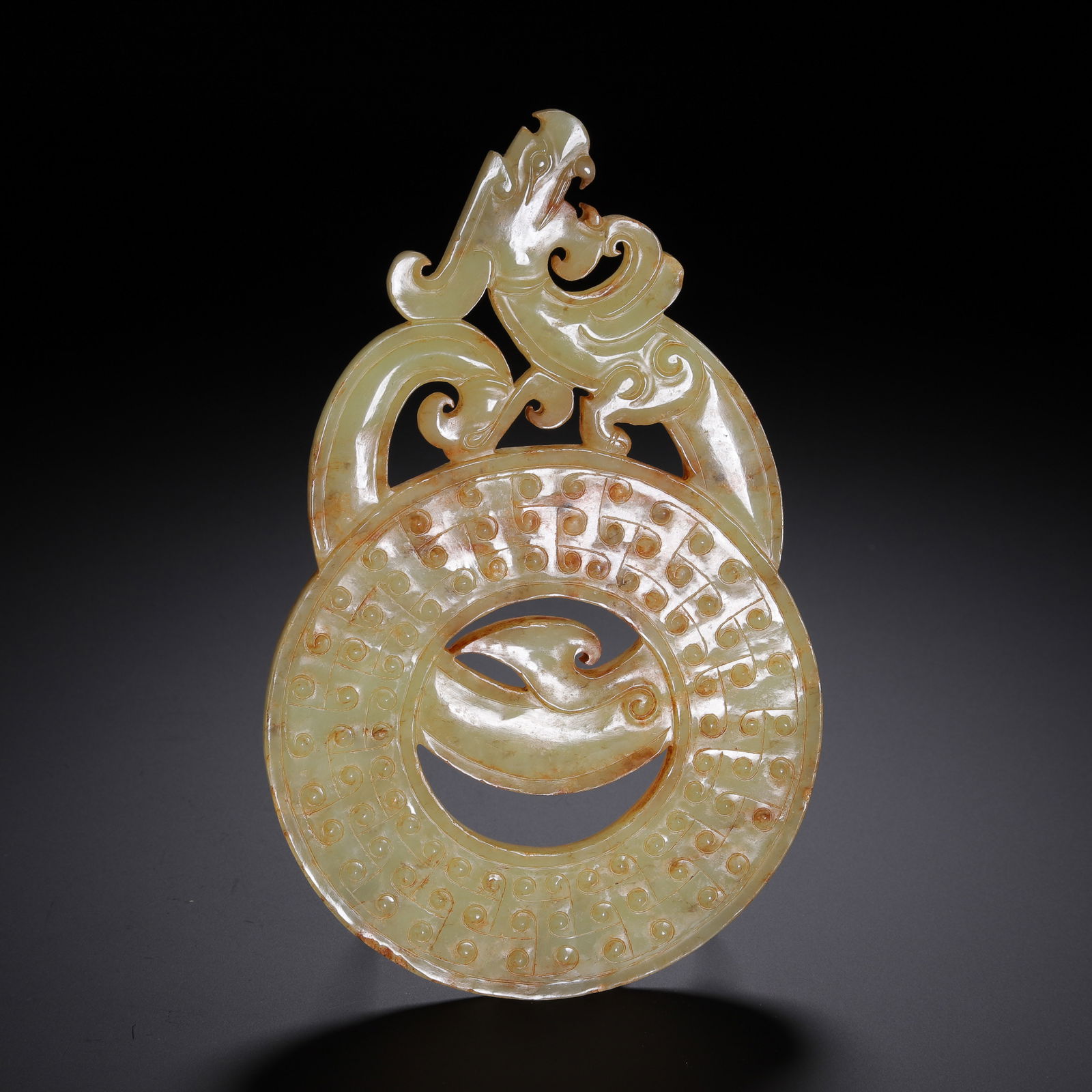 CHINESE ARCHAIC JADE DRAGON PENDANT: Dimensions: L. 15.5 cm. W. 10 cm. Weight 140 grams. This spectacular Chinese archaic jade pendant features a large, circular bi disc, its surface densely decorated with classic raised grain motifs. At