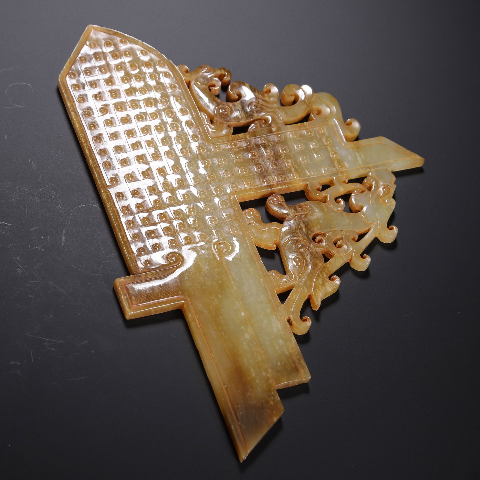 CHINESE ARCHAIC JADE GUI TABLET: Dimensions: L. 21 cm. W. 15 cm. Weight 190 grams. This imposing Chinese archaic jade gui tablet is carved from translucent honey-toned stone with subtle russet inclusions, featuring a classic