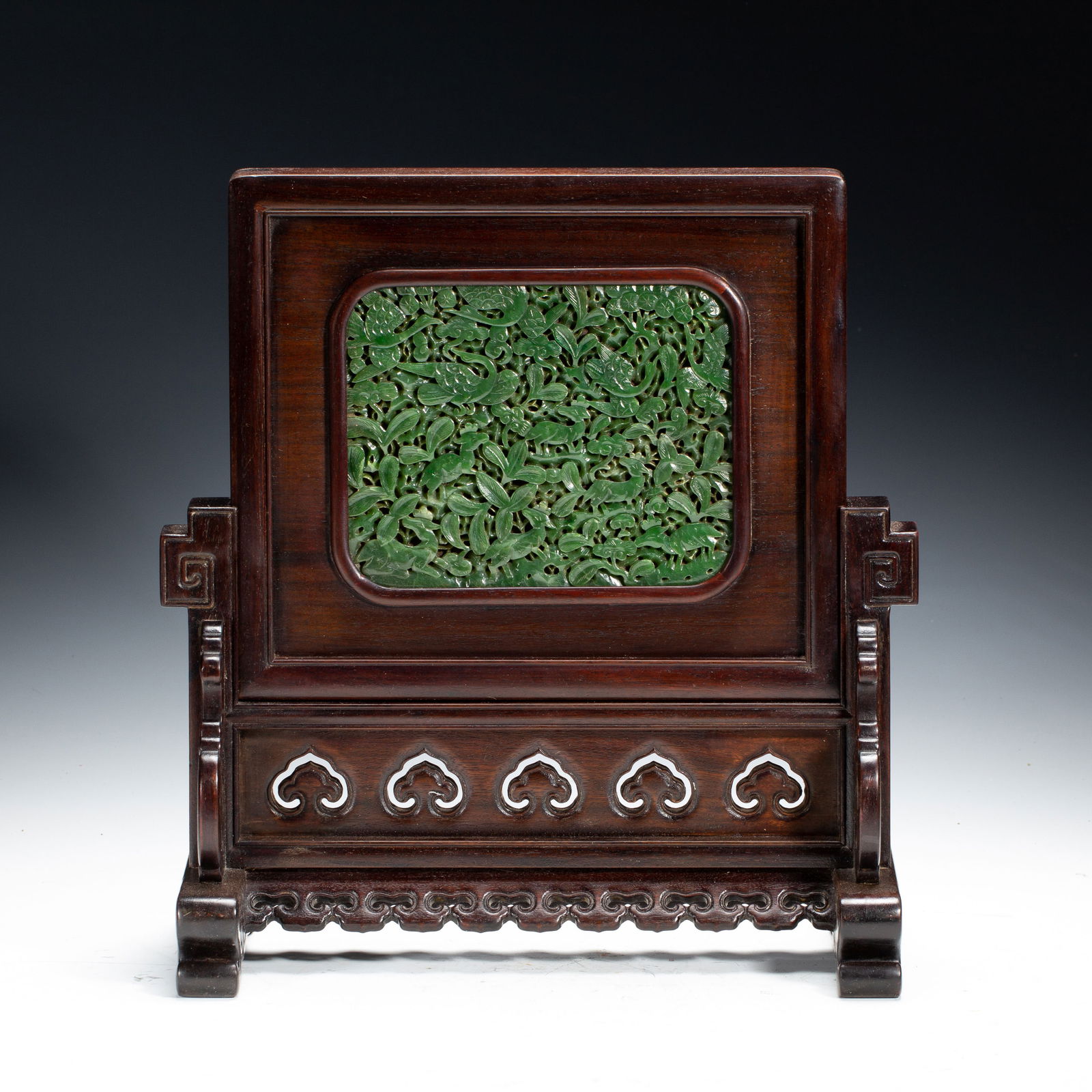 CHINESE SPINACH JADE TABLE SCREEN: Dimensions: L. 31 cm. W. 15 cm. H. 35 cm. Weight 1910 grams. This elegant Chinese table screen features a rich spinach-green Hetian jade plaque, intricately carved in openwork with a dense pattern of