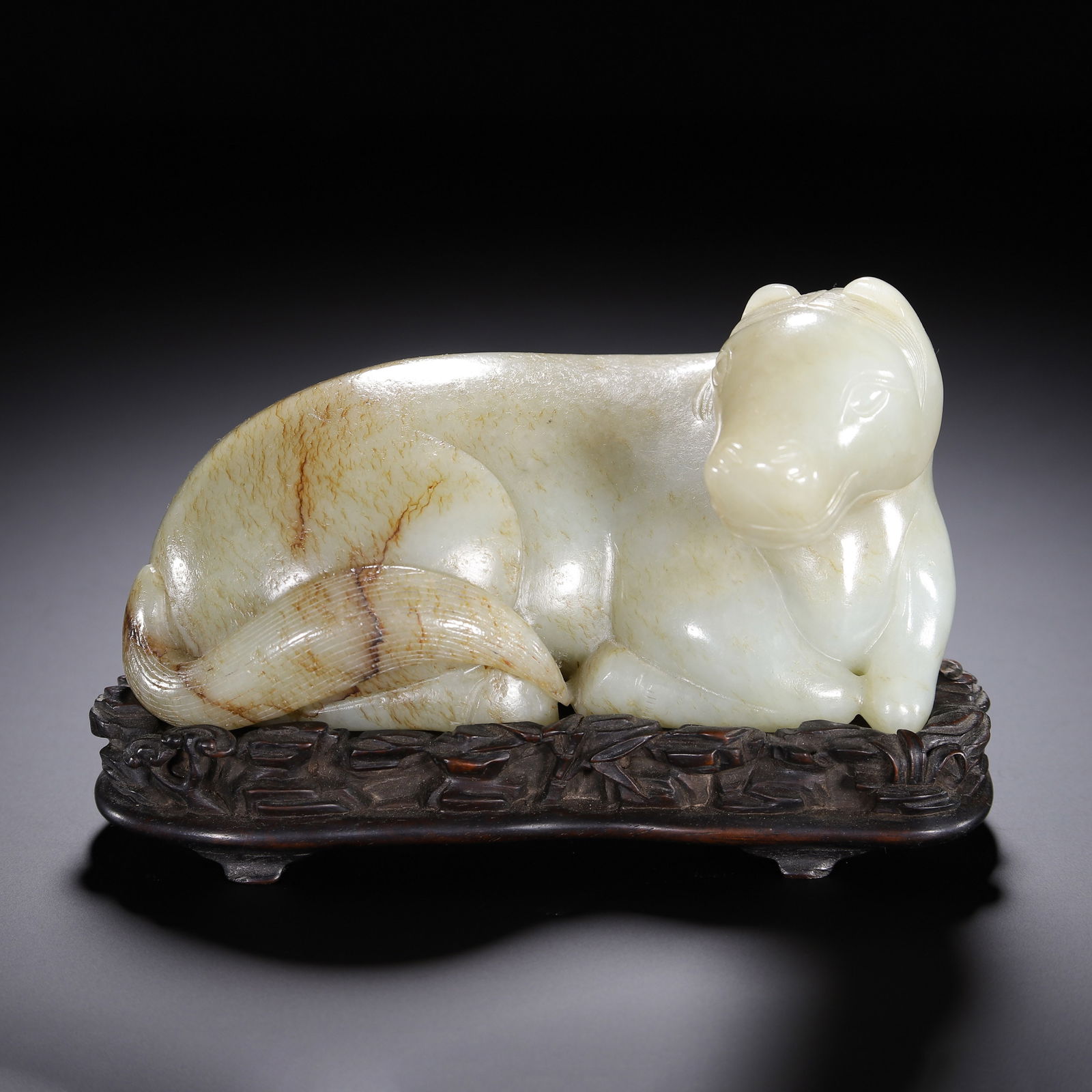 CHINESE WHITE JADE RECUMBENT HORSE: Dimensions: L. 14 cm. W. 8 cm. H. 9 cm. Weight 1010 grams. This elegant Chinese carving depicts a recumbent horse, rendered from translucent white Hetian jade with natural russet veining. The horse is
