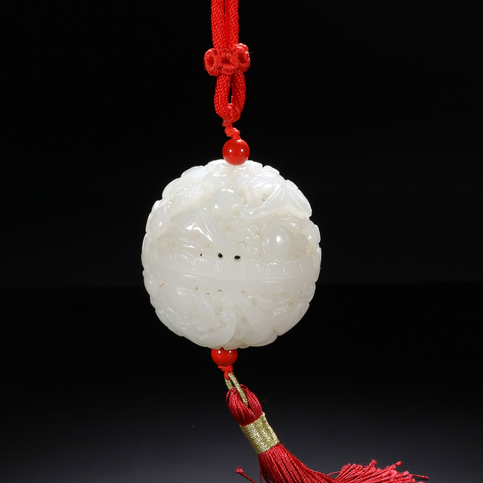 CHINESE WHITE JADE OPENWORK POMANDER: Dimensions: Diam. 5.5 cm. This exquisite Chinese pomander is carved from translucent Hetian white jade, featuring a spherical form with intricate openwork of scrolling foliage and auspicious motifs. T