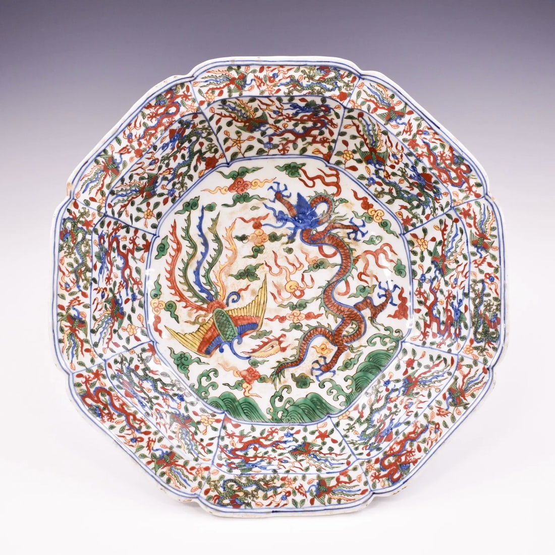 WANLI FLORI FORM WUCAI DRAGON & PHOENIX BASIN: Measurements: 3-1/2" H x 15" W Chinese Ming Wucai porcelain basin is sturdily potted in a deep vessel with broad octagonal flori-form lobed petal rim, gracefully raised from steep sides over wide broa