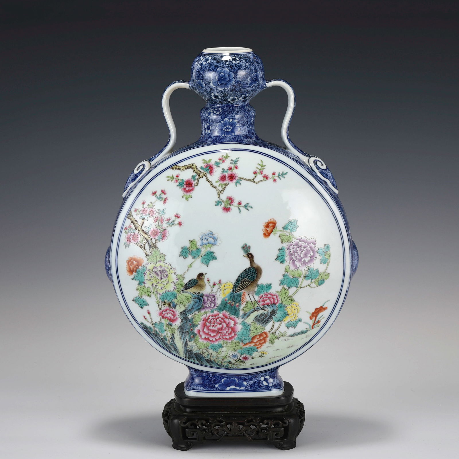 QIANLONG FAMILLE ROSE MOON VASE ON STAND: Dimensons: Length: 28cm, Width: 14cm, Height: 43cm Chinese Qing Dynasty Qianlong Famille Rose Peacock Porcelain Moon Vase On Carved Hardwood Stand. The porcelain potted in moon vase, thick and tall, f