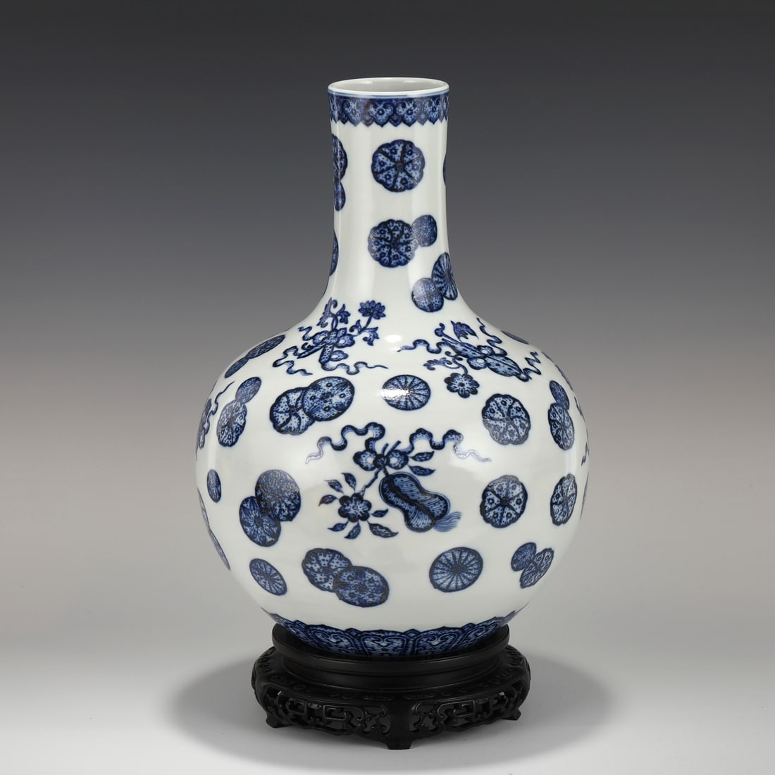 QIANLONG BLUE & WHITE FLORAL MEDALLION PORCELAIN VASE ON STAND: Measurements: Height: 39 cm, Diam.: 25 cm Chinese Qing Dynasty QianLong Blue & White Flori Medallion Motif Porcelain Vase On carved Hardwood Stand. Potted in a reward shaped vase, globular body, long