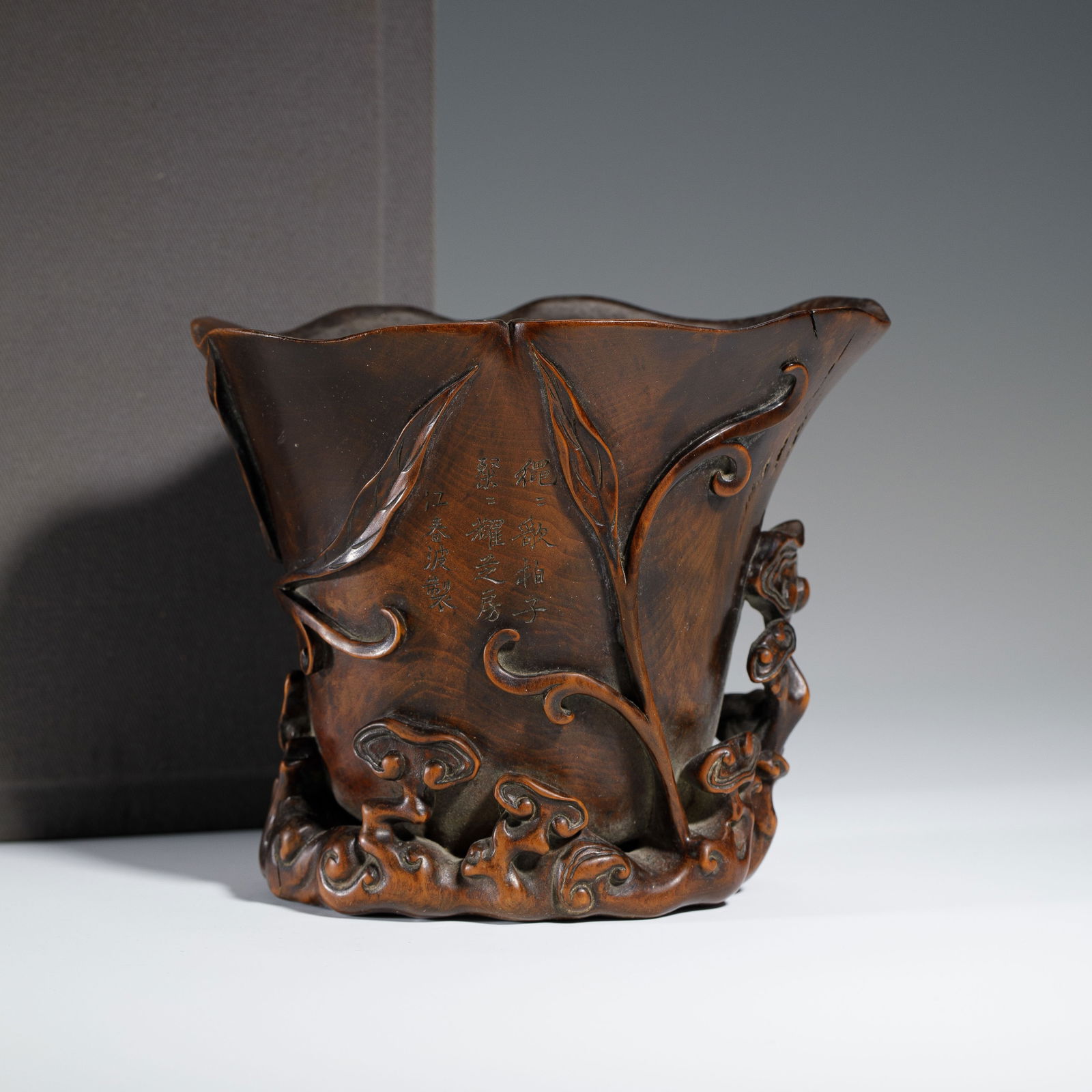 CHINESE BOXWOOD JUE CUP: Dimensions: L. 12.7 cm. W. 9.8 cm. H. 10.5 cm. Weight 255 grams. This elegant Chinese boxwood jue cup is carved in the form of a flowering leaf, with a flared, petal-shaped rim and a sinuous cloud-scr