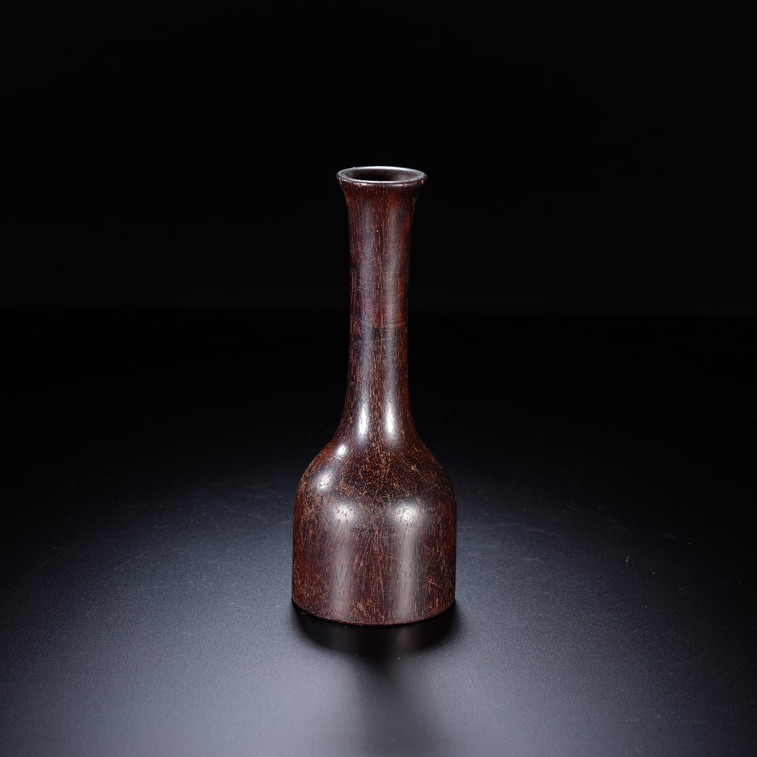 CHINESE ZITAN WOOD VASE: Dimensions: 4x11 cm. This elegant Chinese zitan wood vase features a slender, flared neck rising from a compact, rounded body, carved from dense, richly grained zitan wood with a deep, lustrous dark-b