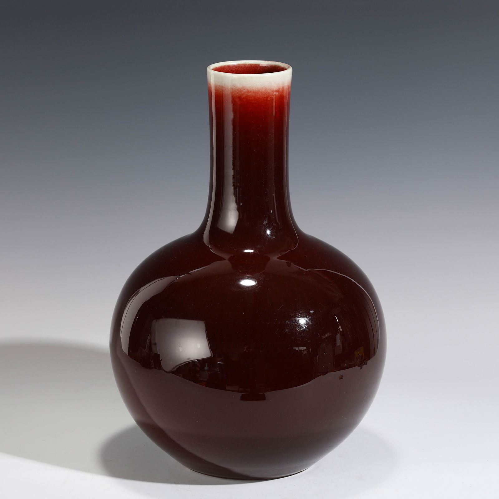 QING FLAMBE RED GLAZED BOTTLE: Dimensions (cm): Height: 38cm, Diam.: 24 Chinese Qing Dynasty Flambe Red glazed Porcelain Bottle Vase. The porcelain potted in large shape bottle vase, thick and tall, globular lower body, straight cy