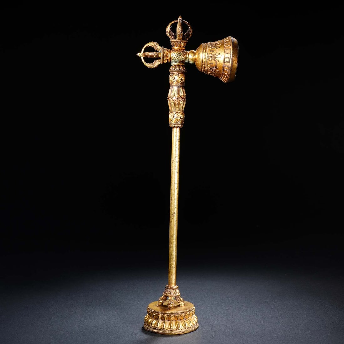 CHINESE GILT BRONZE VAJRA BELL: Dimensions: 10x5.5x31.5 cm. Weight 494 grams. This impressive Chinese gilt bronze vajra bell stands on a lotus base, combining a ritual bell with a five-pronged vajra finial. The long, slender