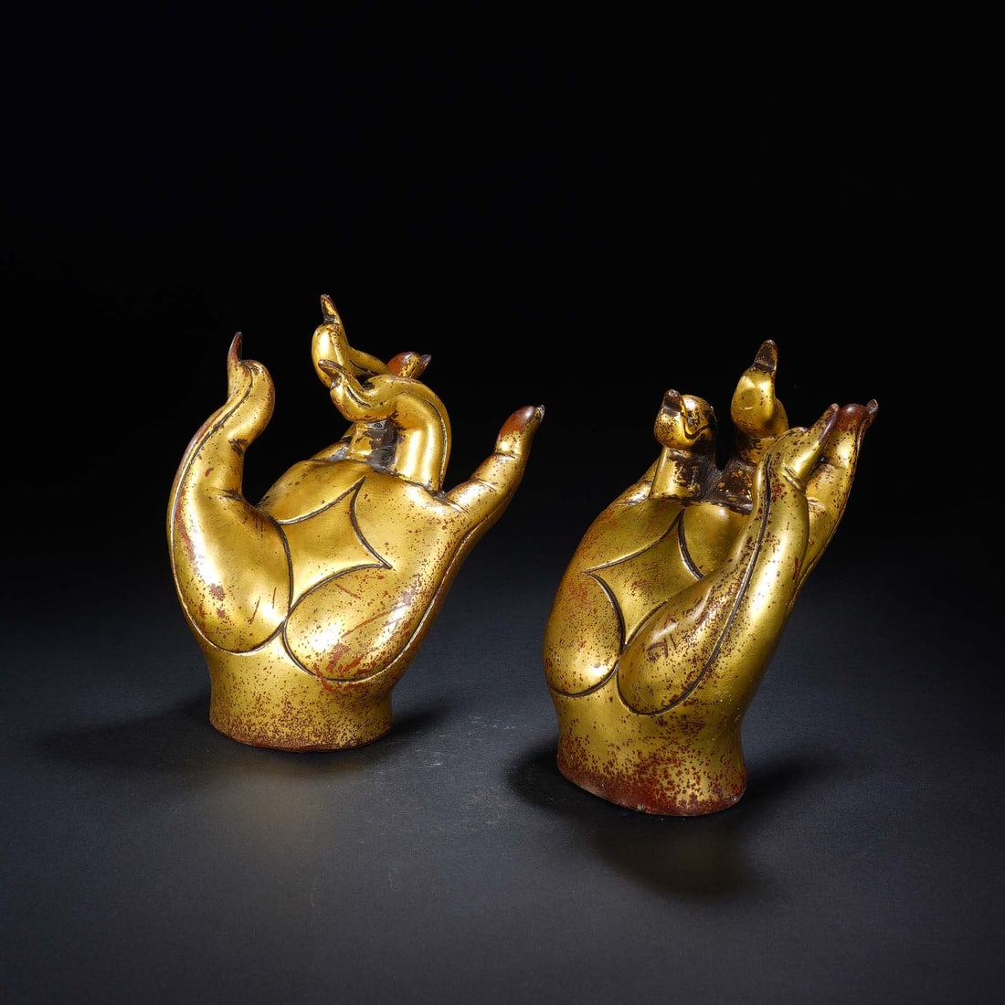 CHINESE GILT BRONZE BUDDHA HANDS: Dimensions: 10x6x13 cm. Weight 2123 grams. This pair of Chinese gilt bronze Buddha Hands showcases the symbolic gesture of spiritual blessing, cast in a lifelike form with delicate finger details and