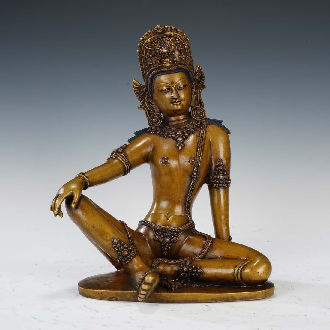CHINESE BRONZE GUANYIN FIGURE: Dimensions: 22x14x27 cm. Weight 3021 grams. This elegant Chinese bronze figure depicts Guanyin, the Bodhisattva of Compassion, in a relaxed ?free and easy? seated posture. She wears an elaborate