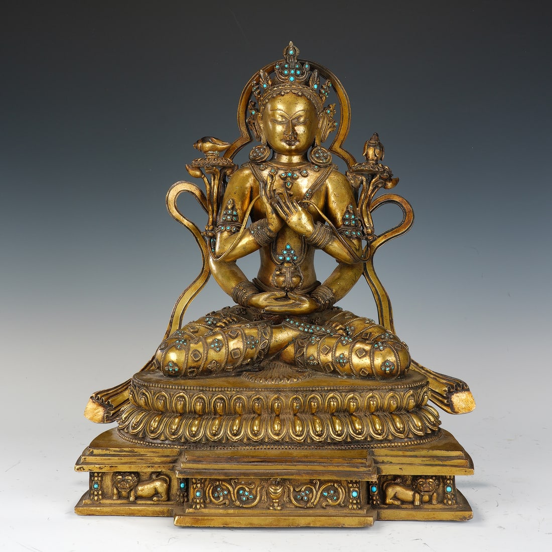 CHINESE GILT BRONZE INLAID DEITY: Dimensions: 36x22x42 cm. Weight 18600 grams. This magnificent Chinese gilt bronze figure depicts a protective deity seated in dhyanasana on a tiered lotus base, adorned with an elaborate crown,