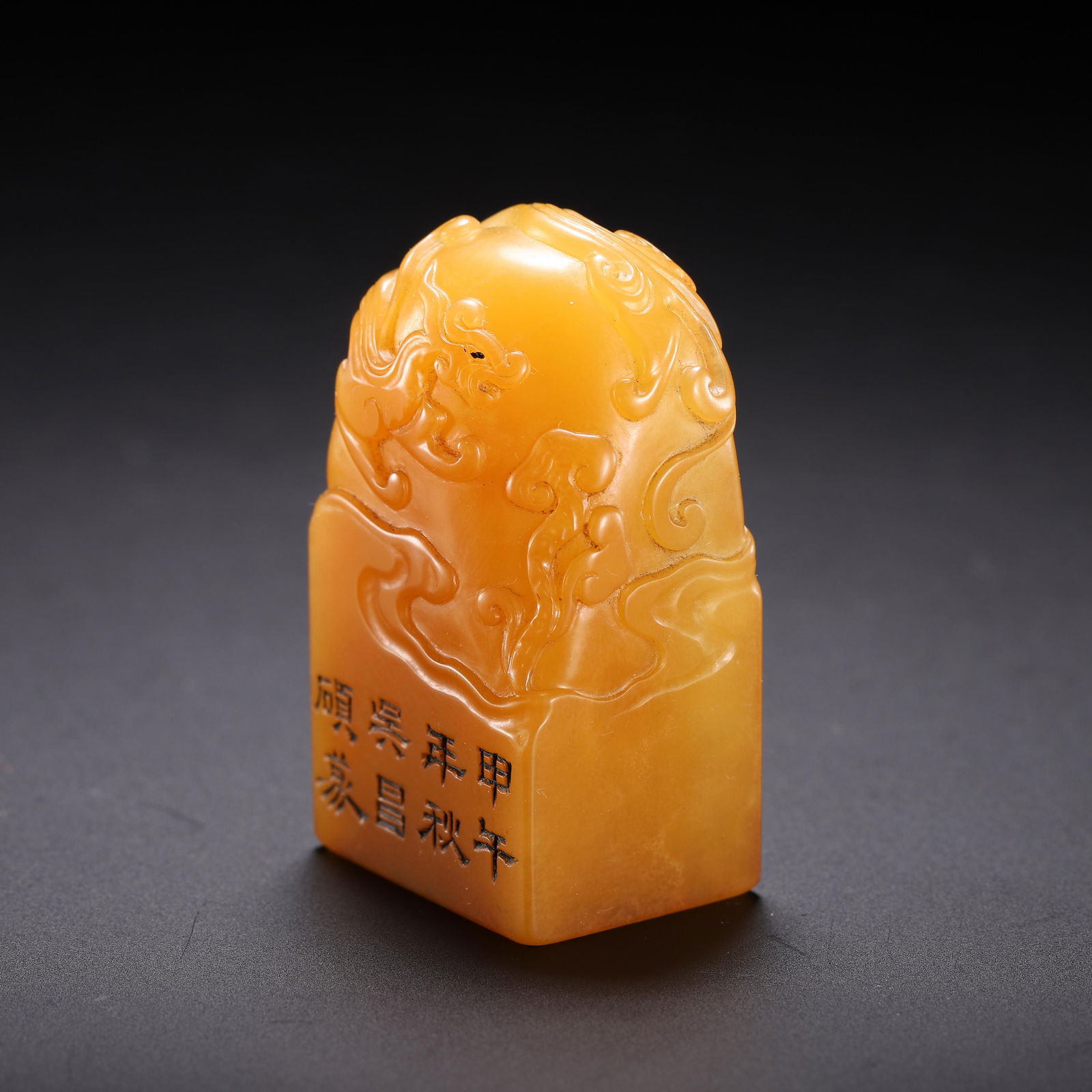 CHINESE TIANHUANG STONE SEAL: Dimensions: H. 4.5 cm. Weight 60 grams. This exquisite Chinese seal is carved from rare, honey-toned Tianhuang stone, featuring a delicate relief of a dragon amid swirling clouds on its domed top. The