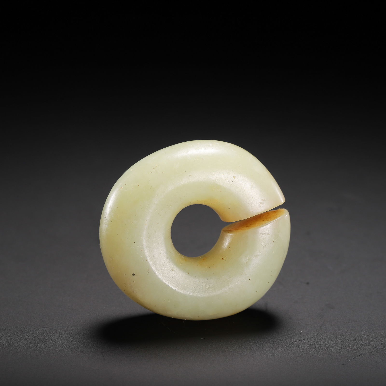 CHINESE HETIAN JADE HUAN PENDANT: Dimensions: H. 3 cm. This ancient Chinese huan pendant is carved from Hetian jade of a soft, creamy yellow hue, featuring a classic notched ring form. Its smooth, polished surface shows subtle signs o