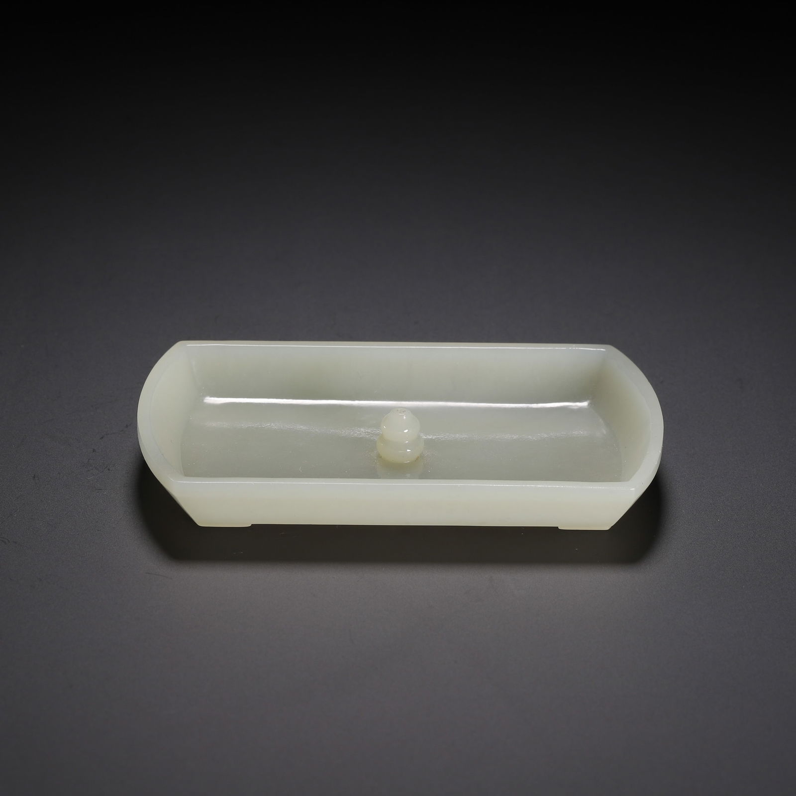 CHINESE HETIAN JADE INCENSE HOLDER: Dimensions: L. 9.8 cm. W. 6 cm. H. 1.6 cm. Weight 60 grams. This elegant Chinese Hetian jade incense holder features a sleek, elongated boat form, carved from a single piece of luminous, pale celadon