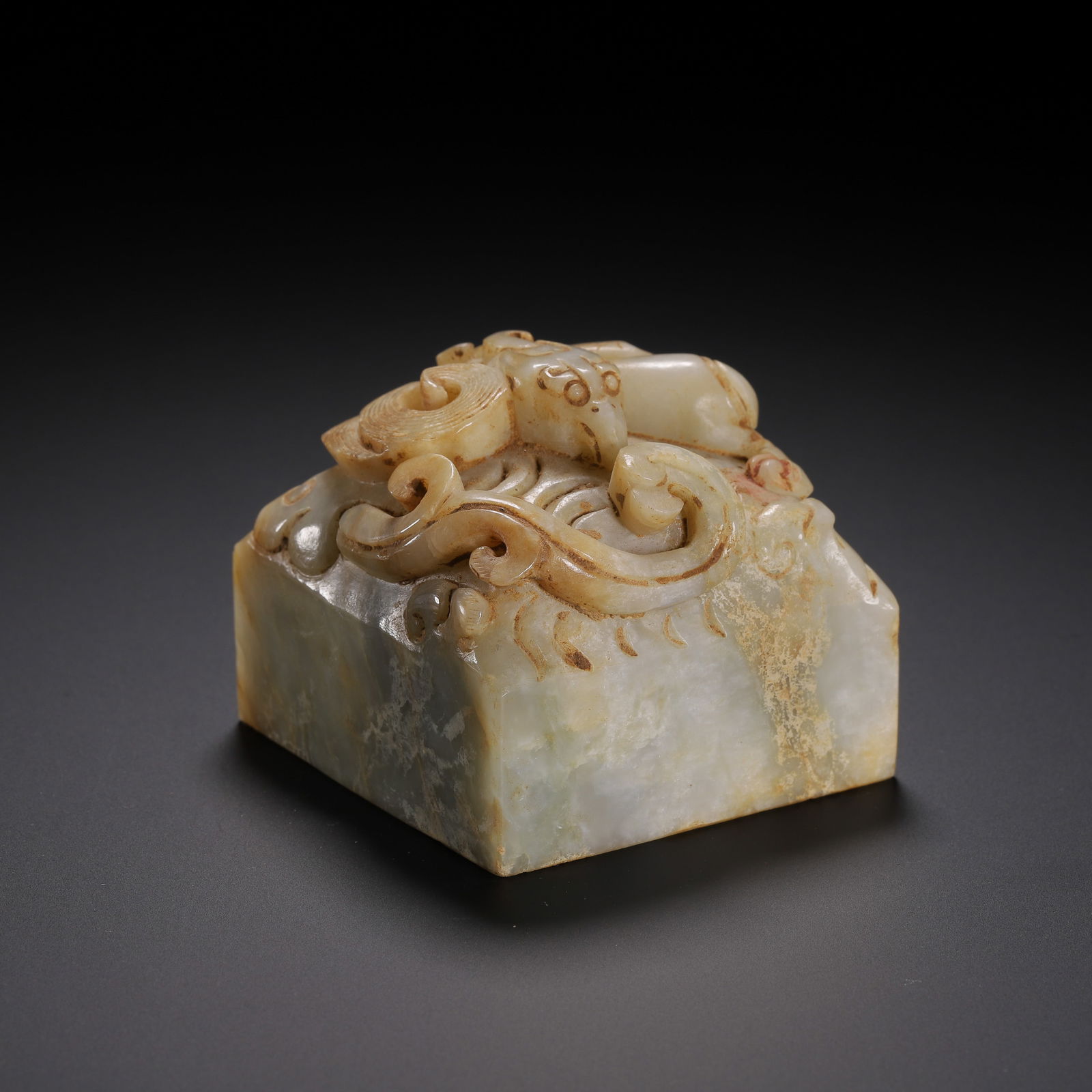CHINESE ARCHAIC JADE SEAL: Dimensions: L. 6 cm. W. 6 cm. H. 5 cm. Weight 410 grams. This substantial Chinese archaic jade seal features a square base surmounted by a dynamically carved chilong dragon finial. The translucent sto