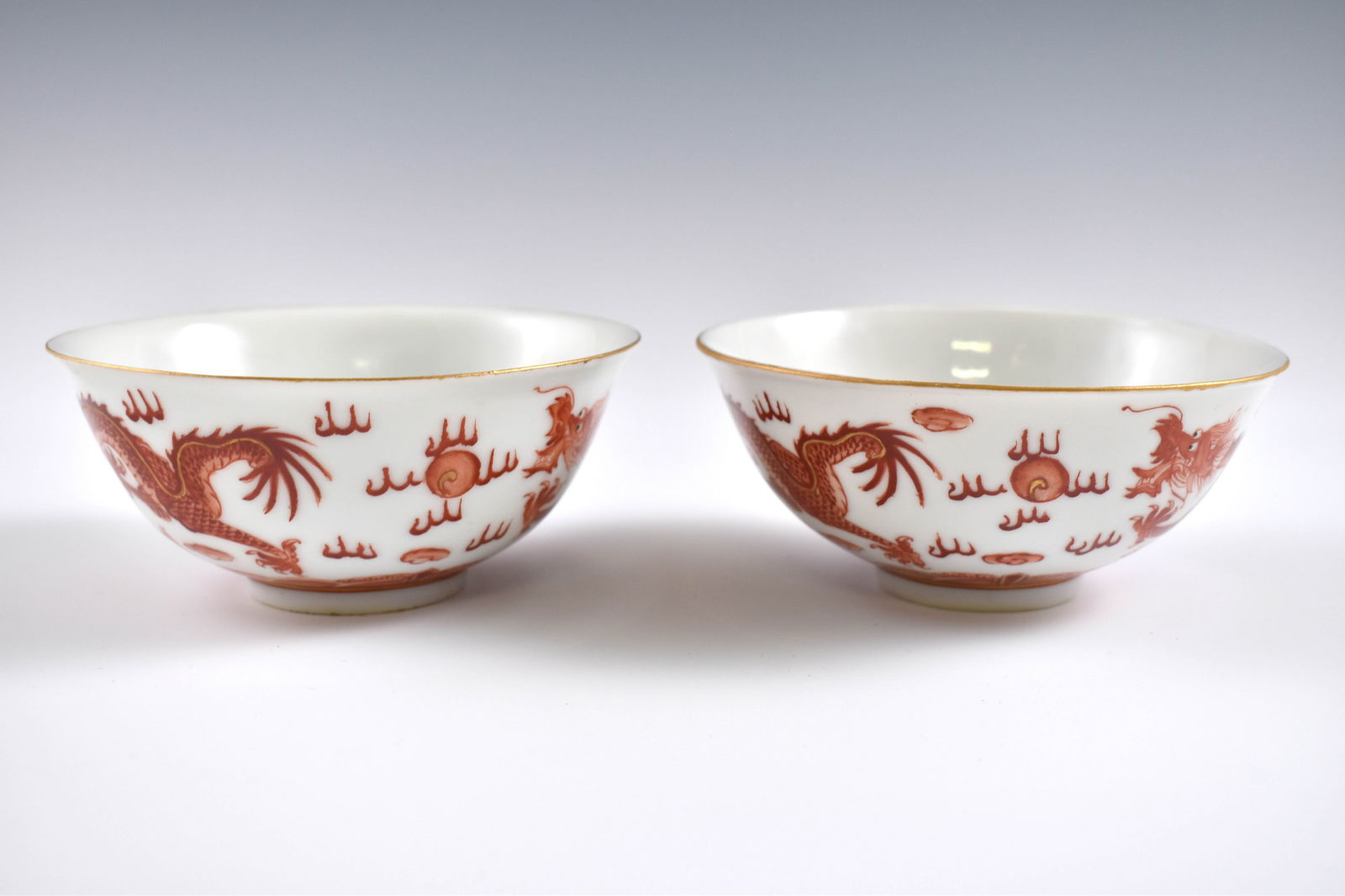 PR. QING RED & WHITE DRAGON BOWLS: Dimensions: 2-1/4" H x 4-7/8" Dia. (each) Pair of Chinese Qing Dynasty Period, Red & white dragon bowls. Potted with a shallow body, slight deep, thick and bulbous body, with angled cavetto elevated t