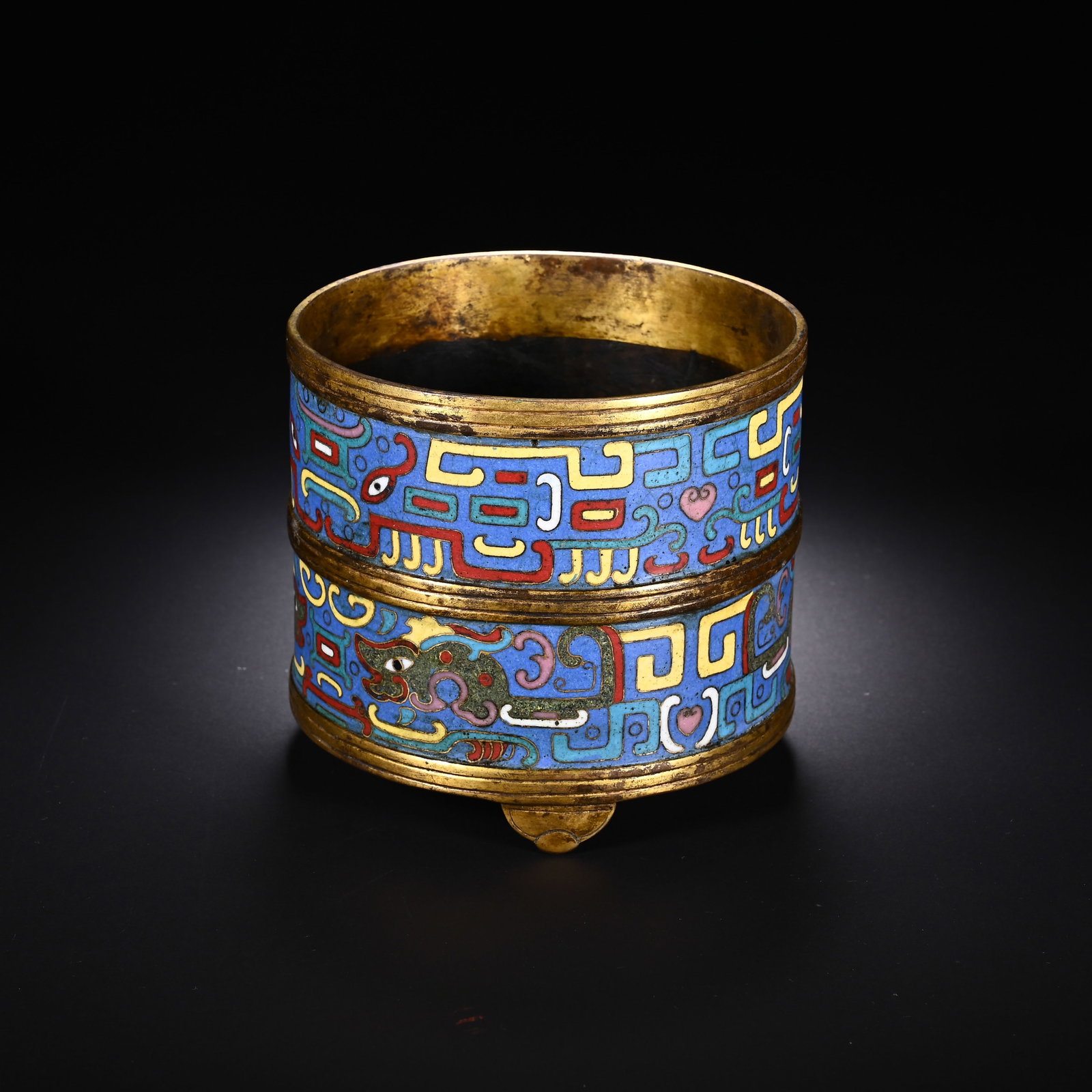 A CHINESE GILT CLOISONNE DRAGON PATTERN CENSER: Standing 9.7 cm in height and measuring 10.7 cm in width, this cylindrical censer is crafted from gilded copper adorned with elaborate cloisonn? enamelwork. Two stacked decorative bands rest upon a vi