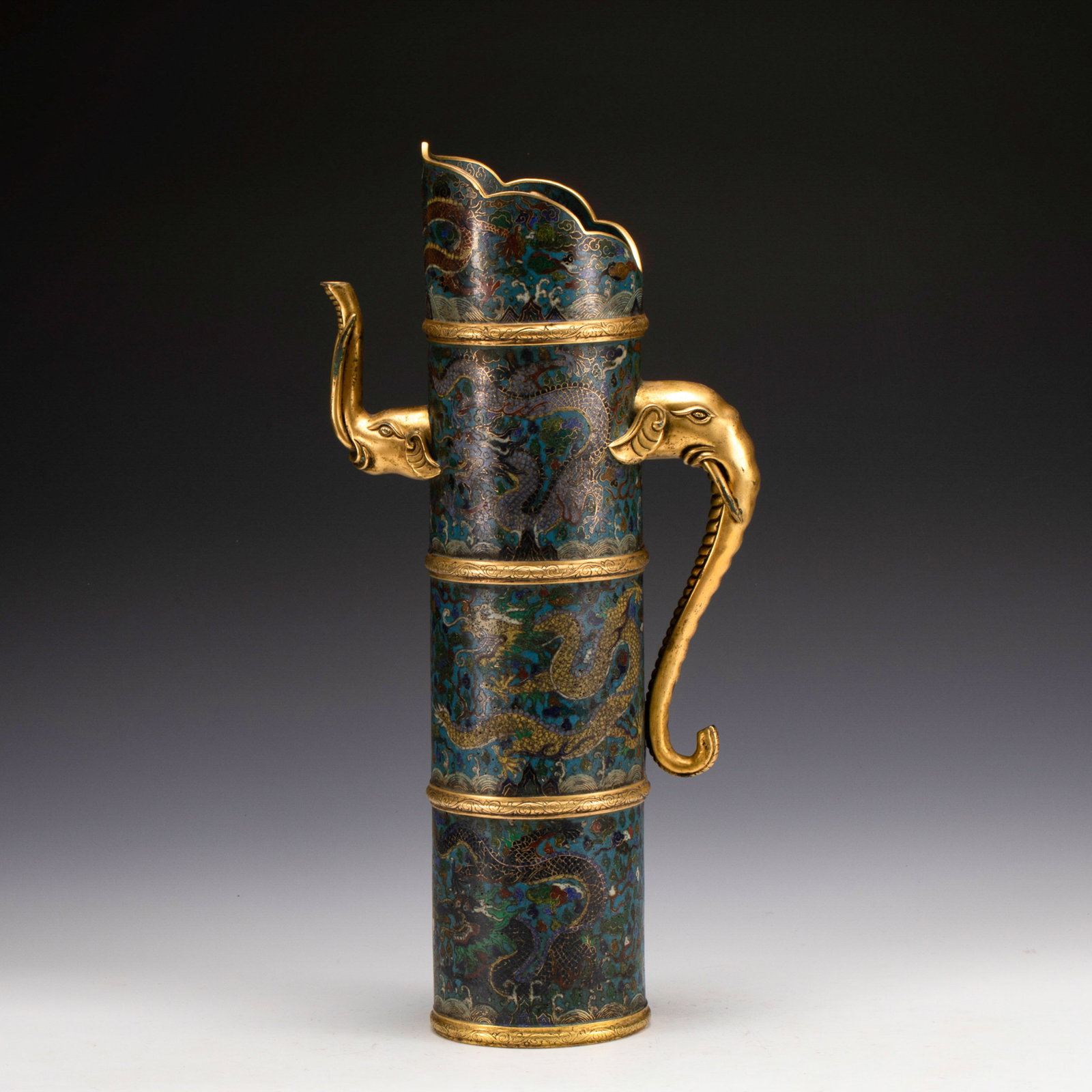 QING GILT BRONZE CLOISONNE ELEPHANT MOUTH POT: Measurements: Length: 22 cm, Width: 11.5 cm, Height: 46 cm, Weight: 3630g Qing Dynasty Qianlong Gilt Bronze Cloisonne Elephant Mouth Pot. This Gilt Bronze Cloisonne is cast with wine spout on the cyli