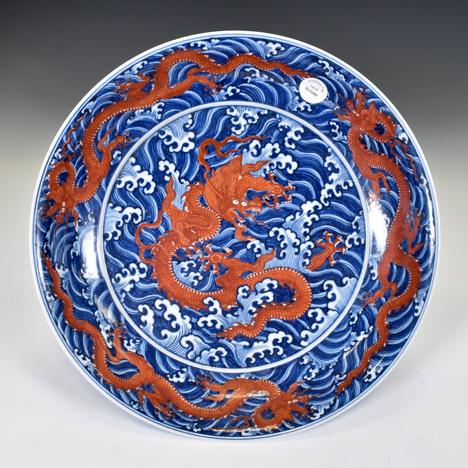 QING RED DRAGON & BLUE PORCELAIN PLATE: Dimensions: 13" Diameter. A Large Underglaze-Blue and Iron-Red ?Dragon and Waves? ChargerBoldly decorated in vivid underglaze cobalt and iron-red, the charger displays a dramatic composition of stridi