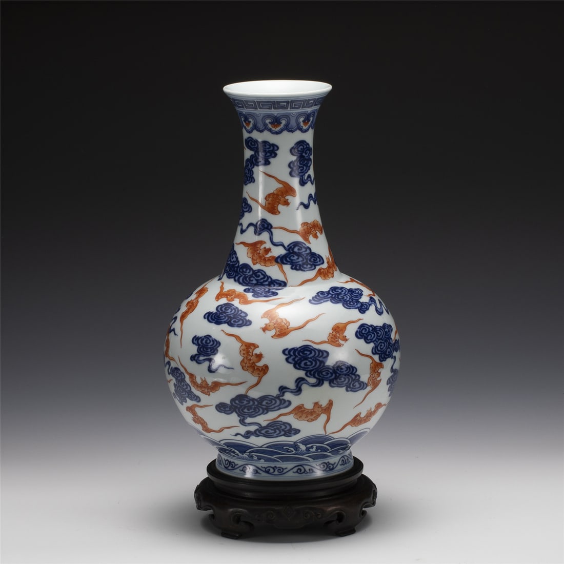 QIANLONG BLUE & WHITE RED HUNDRED BAT VASE ON STAND: Measurements: Length: 19.8 cm, Height: 32.2 cm Chinese Qing Dynasty Qianlong Blue and White Red Hundred Bat Porcelain Spring Vase On Carved Hardwood Stand. This vase has a Chinese traditional YuHuChun