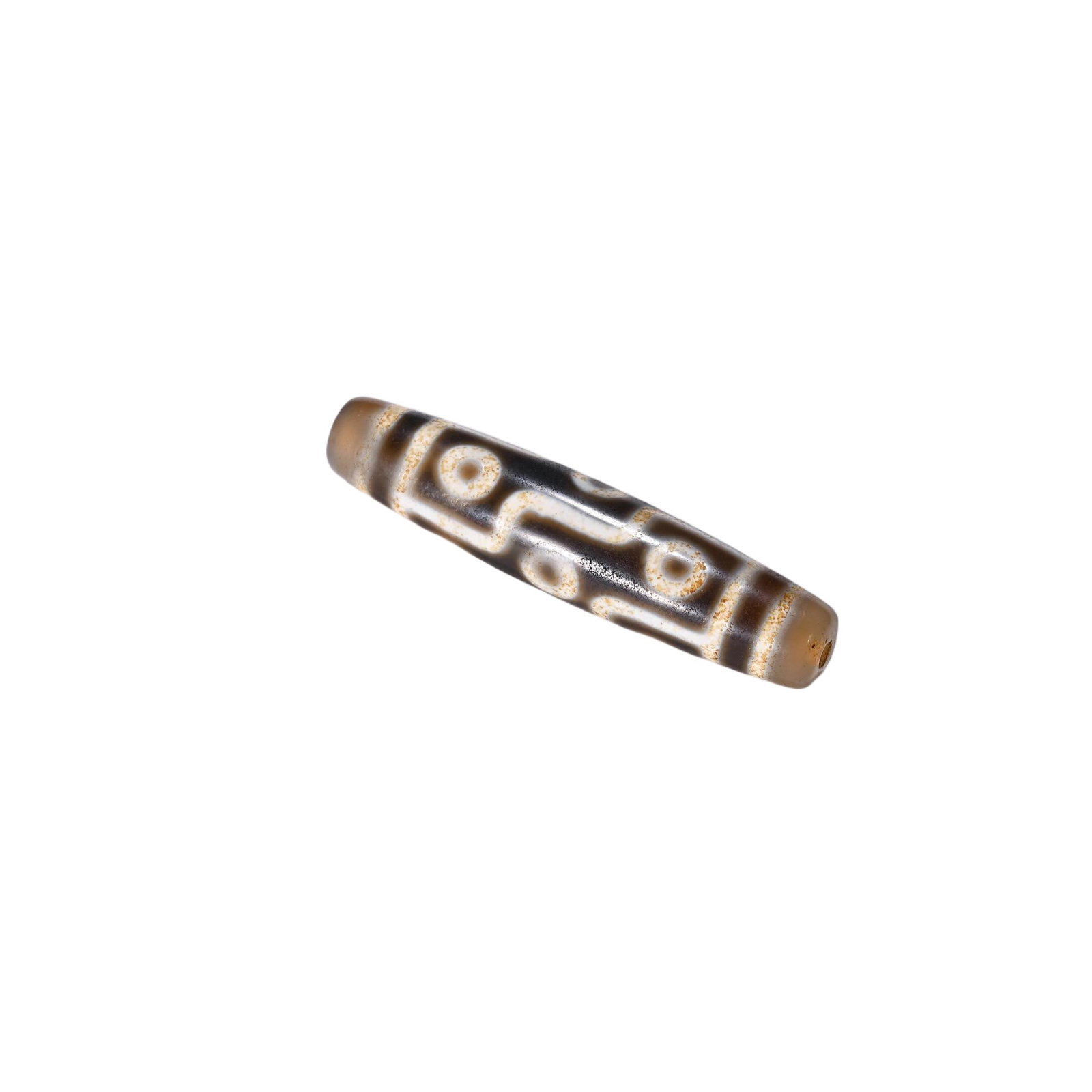 A CHINESE TIBETAN DZI BEAD: Measuring 5.7 cm in length, this elongated cylindrical dzi bead boasts a polished agate base with warm translucent tan tones at both tapered extremities. Crisp creamy etched bands delineate iconic eye