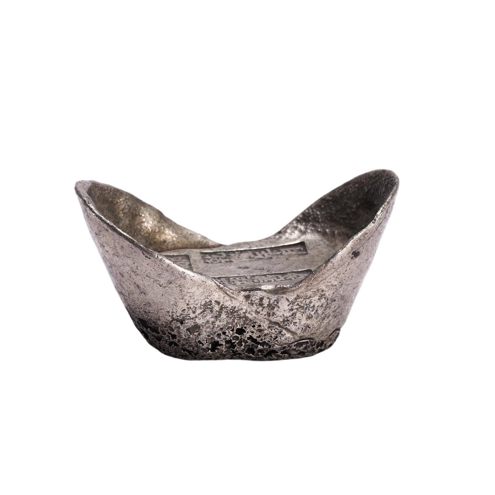 A CHINESE SILVER SYCEE INGOT: Weighing 160 grams and measuring 7 cm long, 3.5 cm wide and 4 cm tall, this compact sycee adopts the traditional upturned-waist boat silhouette. Rectangular stamped hallmarks are visible on its flatte