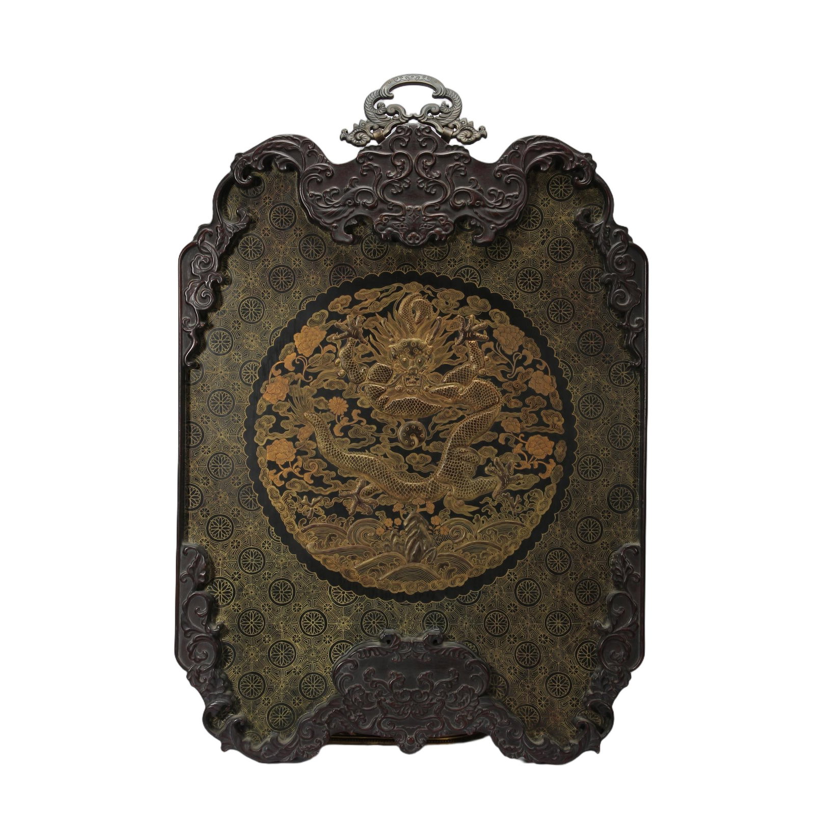 A CHINESE GILT LACQUER DRAGON HANGING SCREEN: Measuring 71 cm in length and 48 cm in width, this refined hanging screen is encased within an ornate dark hardwood frame deeply carved with scrolling foliate motifs, topped by a decorative metal hang