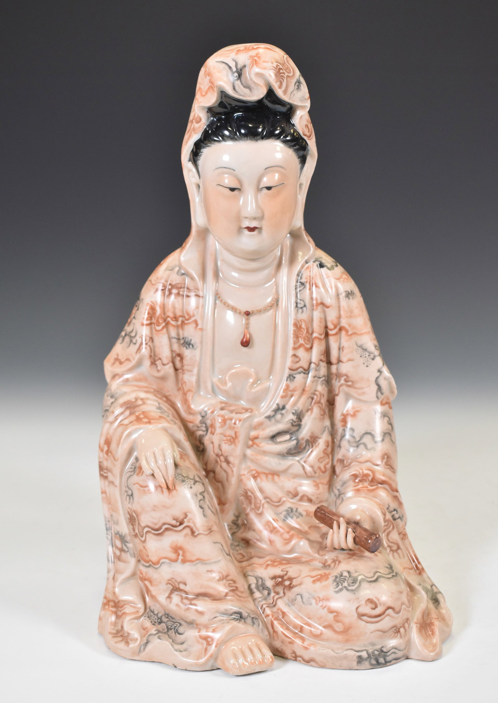 PORCELAIN FIGURE W BROKEN FINGER: Finely potted resembled seated GuanYin. Seated her right knee raised, right hand laying on it. The left hand holding a scroll rest on her lap. The robe decorated with hand painting in grisaille and re
