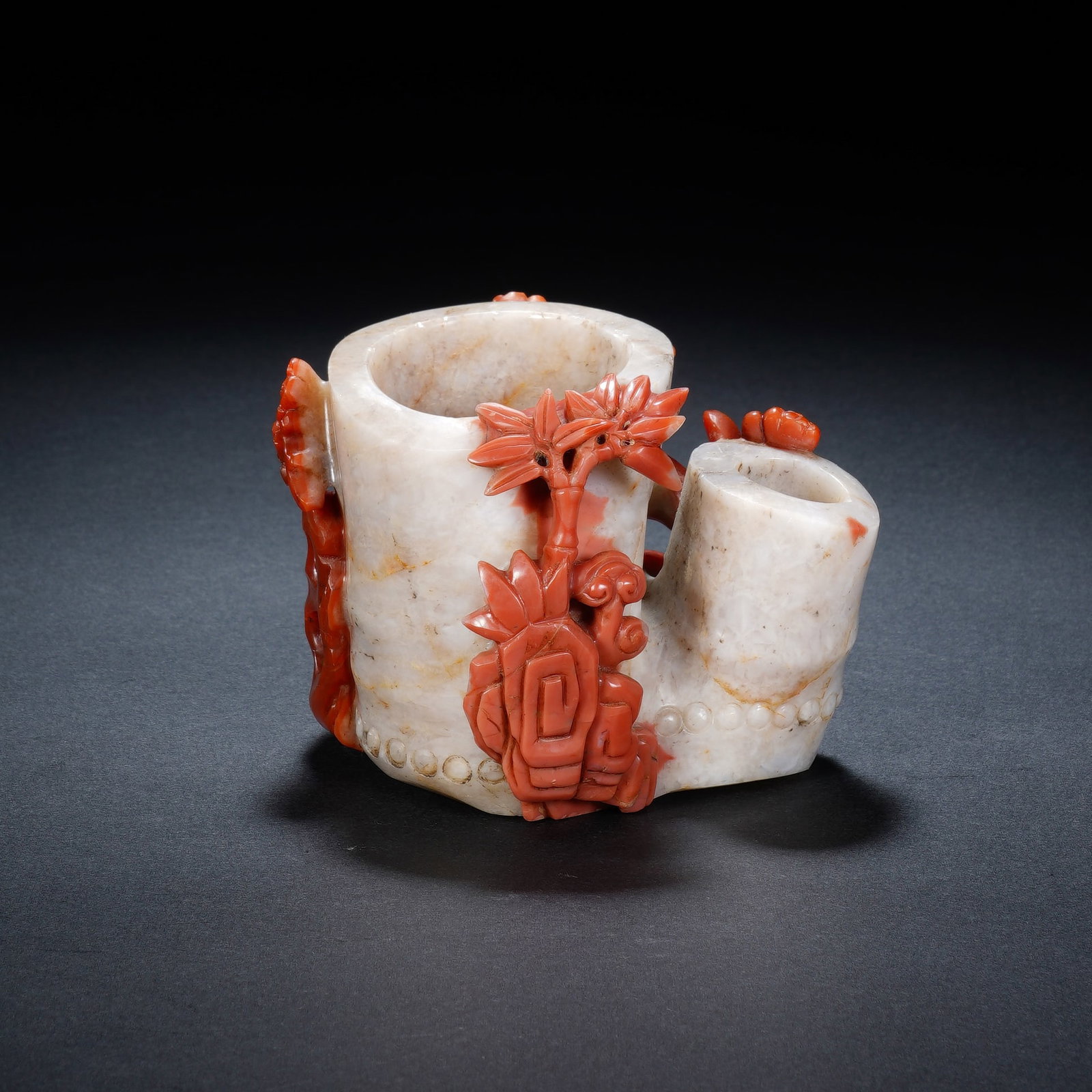 A CHINESE NANHONG STONE FLOWER VASE: Crafted from appealing Nanhong stone with striking natural color differentiation, this dual-cavity flower holder features creamy pale stone forming the main vessel bodies, contrasted by vivid saturate