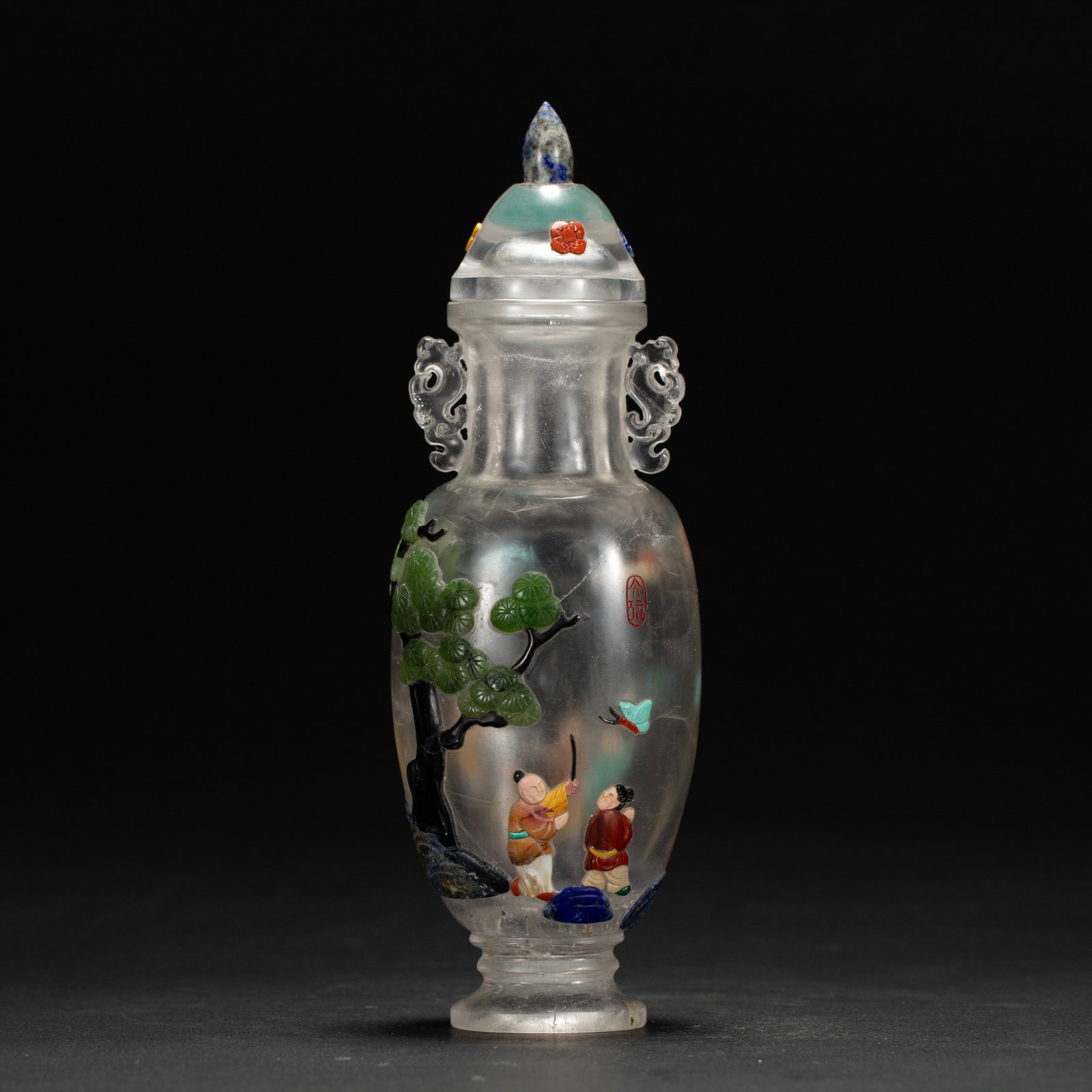 A CHINESE HARDSTONE INLAID CRYSTAL VASE: Weighing 310 grams, this delicate lidded vase measures 5.6 cm long, 5 cm wide and 17 cm in height. Carved from translucent rock crystal, it features intricately pierced scroll-shaped side handles and 