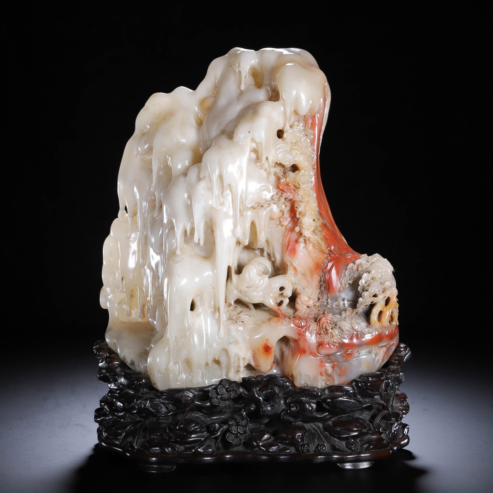 A CHINESE SHOUSHAN STONE MOUNTAIN CARVING: Weighing 5070 grams, this imposing landscape carving measures 20 cm long, 10 cm wide and 28 cm tall. The Shoushan stone exhibits delightful natural colour layering, blending milky creamy sections that
