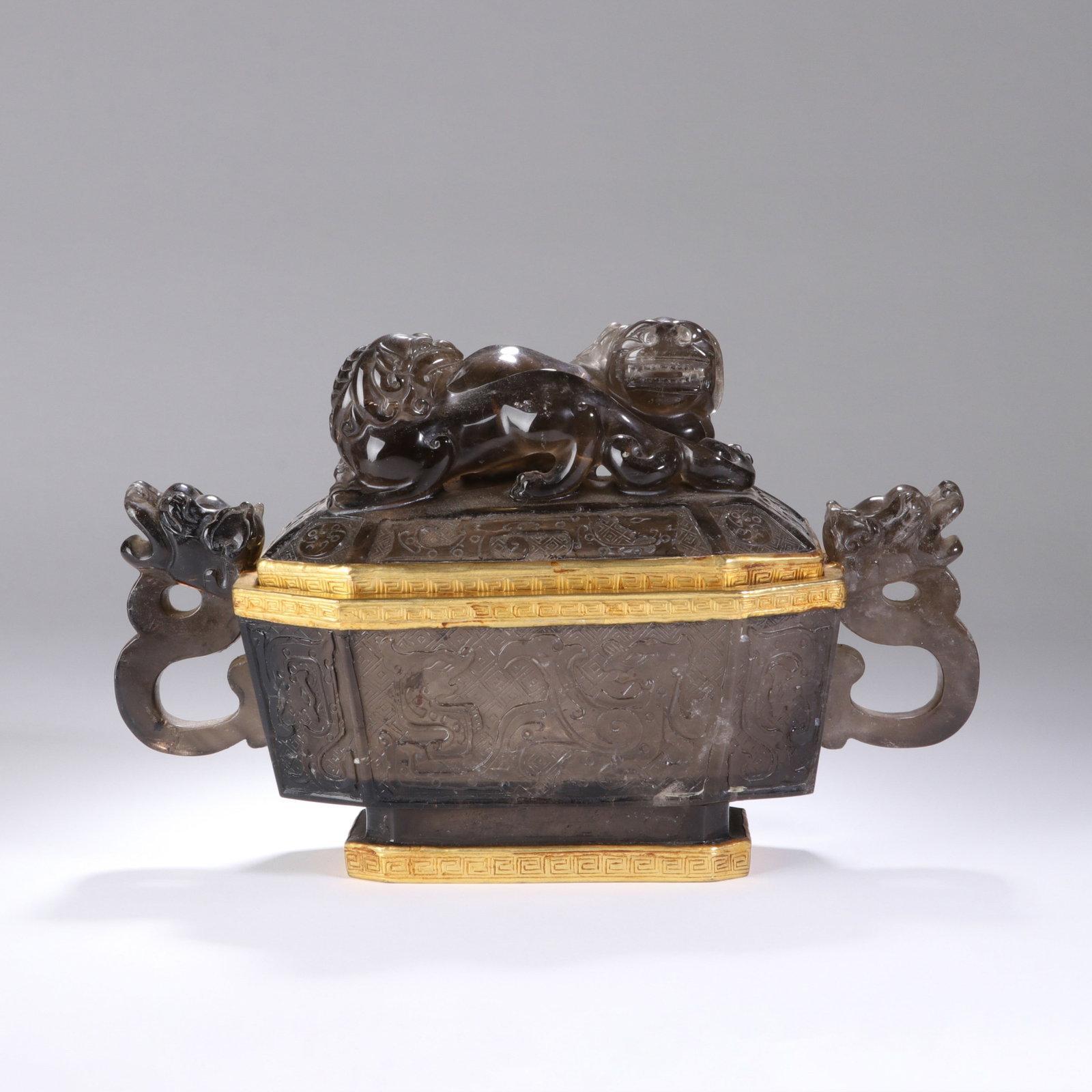A CHINESE CRYSTAL DRAGON MOTIF CENSER: Standing 14 cm high and measuring 21.5 cm across its widest span, this luxurious censer is sculpted from smoky translucent crystal with soft natural tonal depth. Two elaborately carved dragon-head han