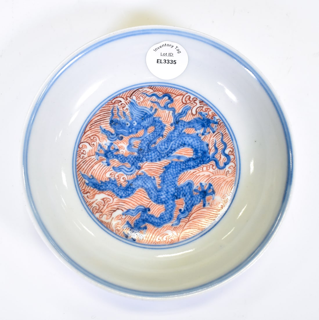 YONGZHENG RED & BLUE DRAGON PORCELAIN PLATE: Dimensions: 6" Diameter A blue and red shallow plate. The center motif is that of a 5-toed dragon superimposed on a background of rouge-de-fer rolling waves. The exterior walls depict nine blue 5-toed