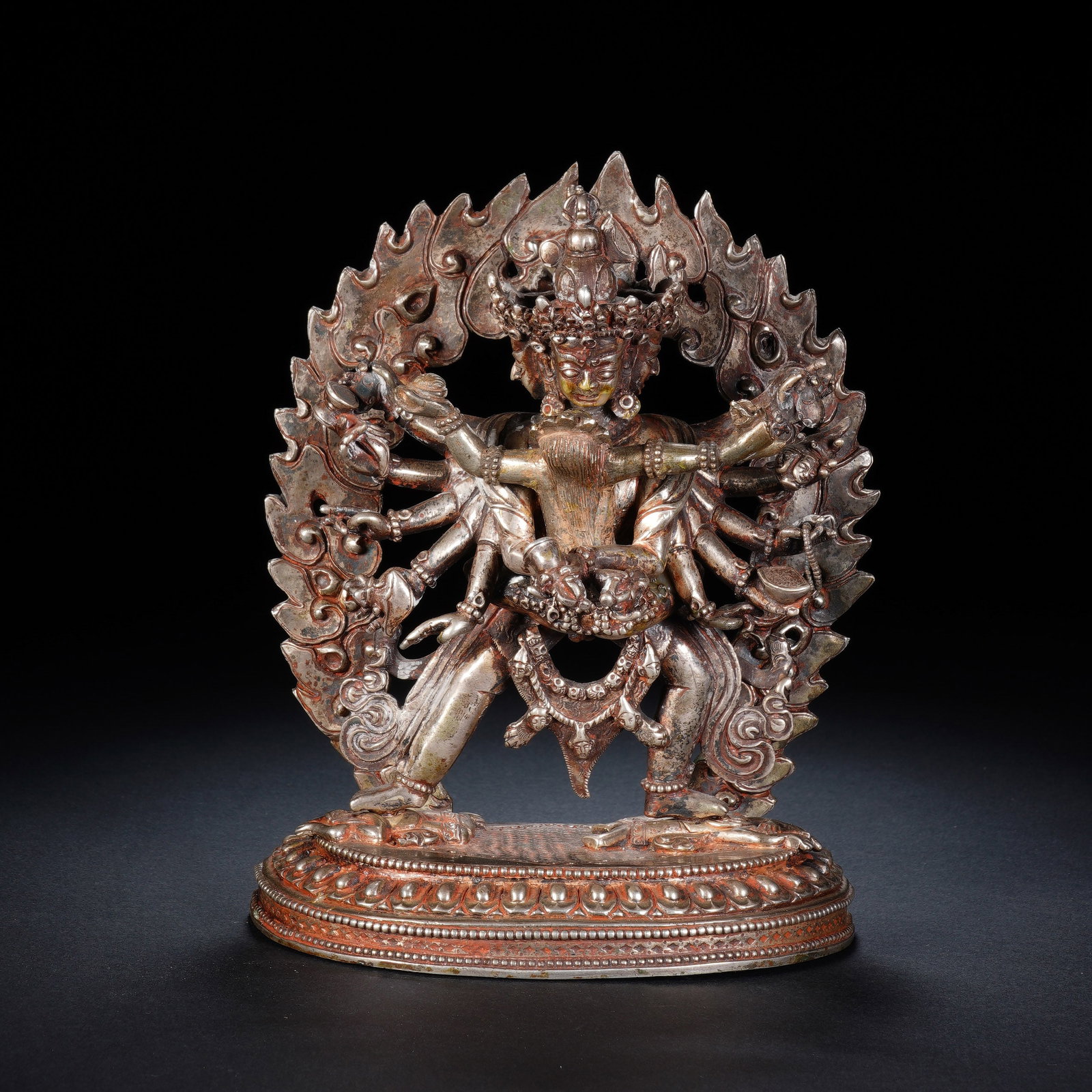 A CHINESE SILVER YAMANTAKA STATUE: Expertly cast from fine pure silver, this intricate Yamantaka sculpture presents the deity with multiple outstretched arms holding varied ritual implements. The deity wears elaborate ornate crowns