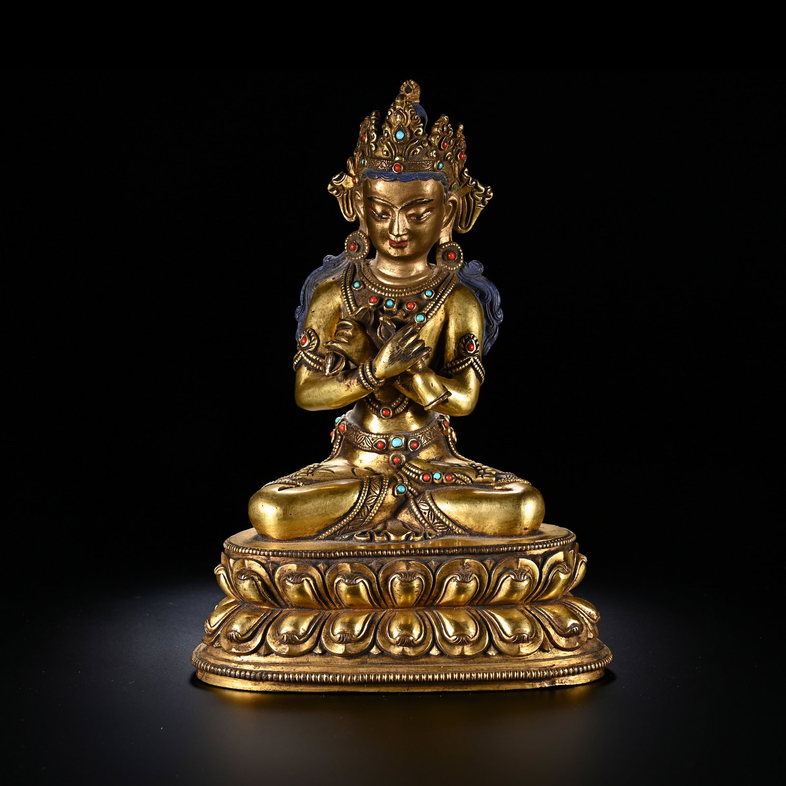 A CHINESE GILT BRONZE BUDDHA: Measuring 17 cm in height and 12 cm in width, this refined gilt bronze deity sits in a poised lotus meditation posture atop a double-tiered lotus pedestal lined with meticulously sculpted overlapping