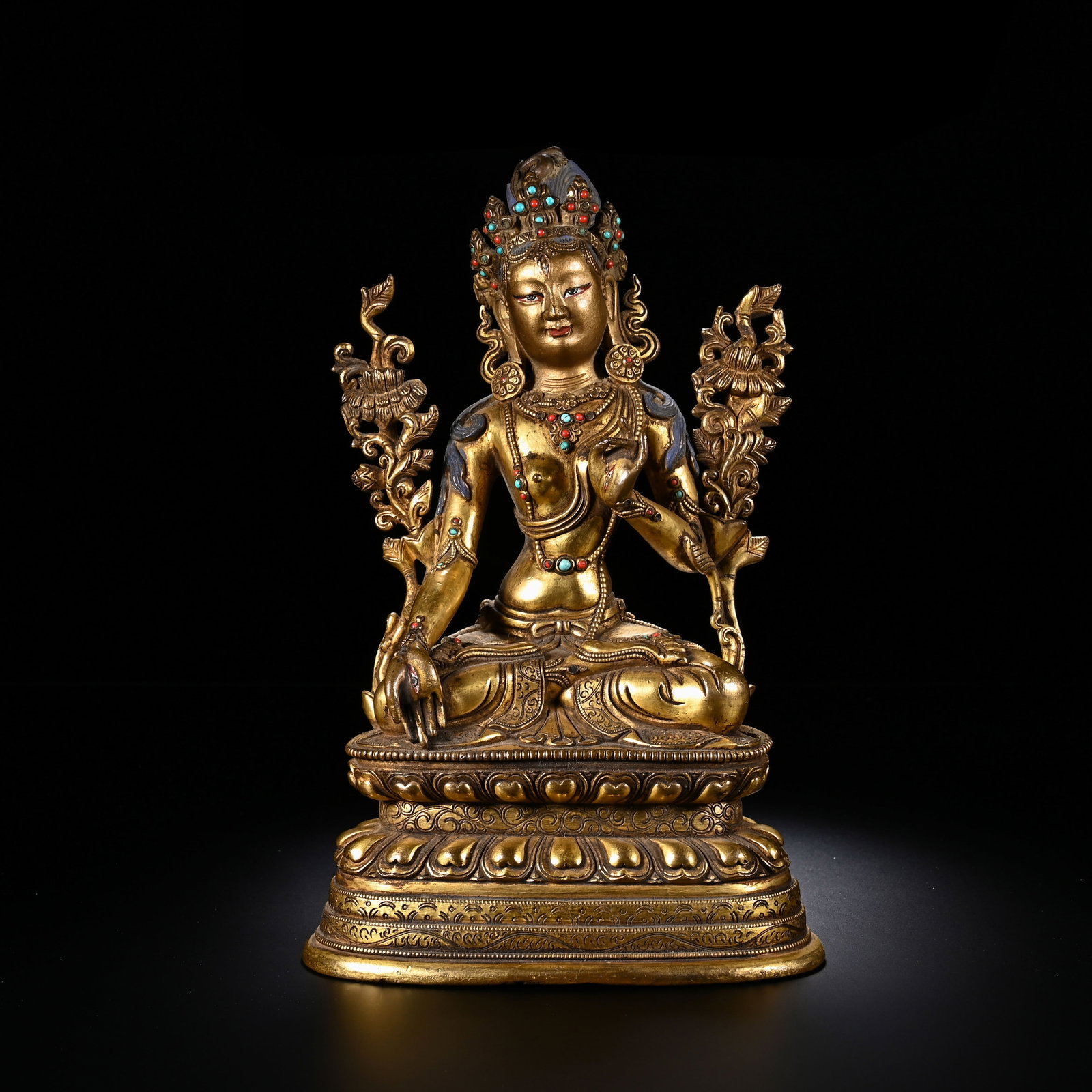 A CHINESE GILT BRONZE BODHISATTVA: Standing 19.5 cm in height with a width of 12.5 cm, this splendid gilt bronze bodhisattva rests in graceful lotus posture upon a multi-tiered lotus pedestal decorated with plump, neatly moulded petals