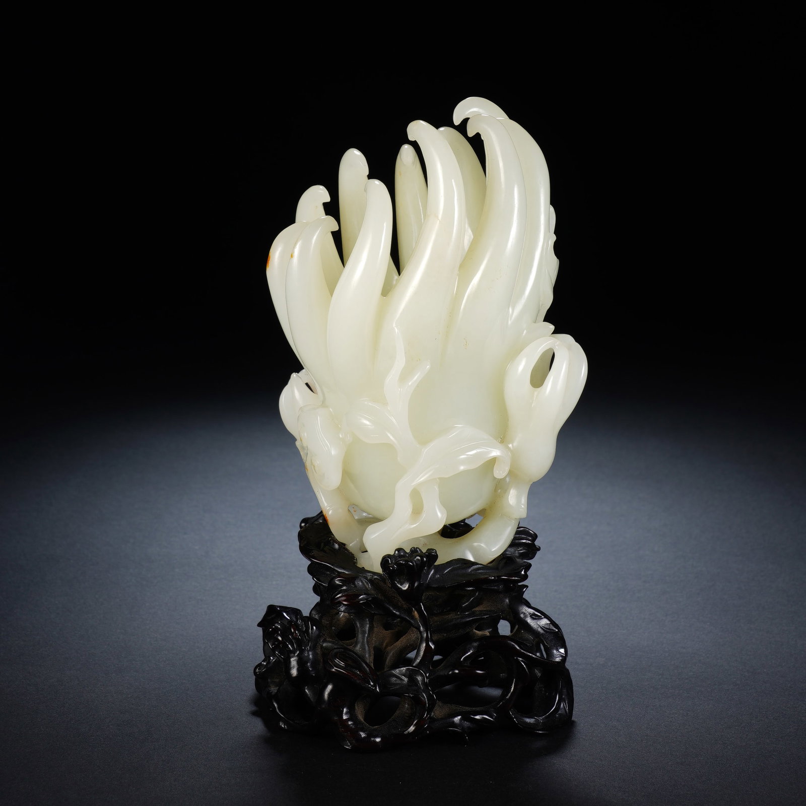 A CHINESE WHITE JADE FINGER CITRON ORNAMENT: Crafted from fine creamy-toned Hotan white jade, the finger citron carving itself measures 8 x 6 x 12 cm, reaching an overall height of 16 cm with its fitted stand and weighing 461 grams. Curved, tape