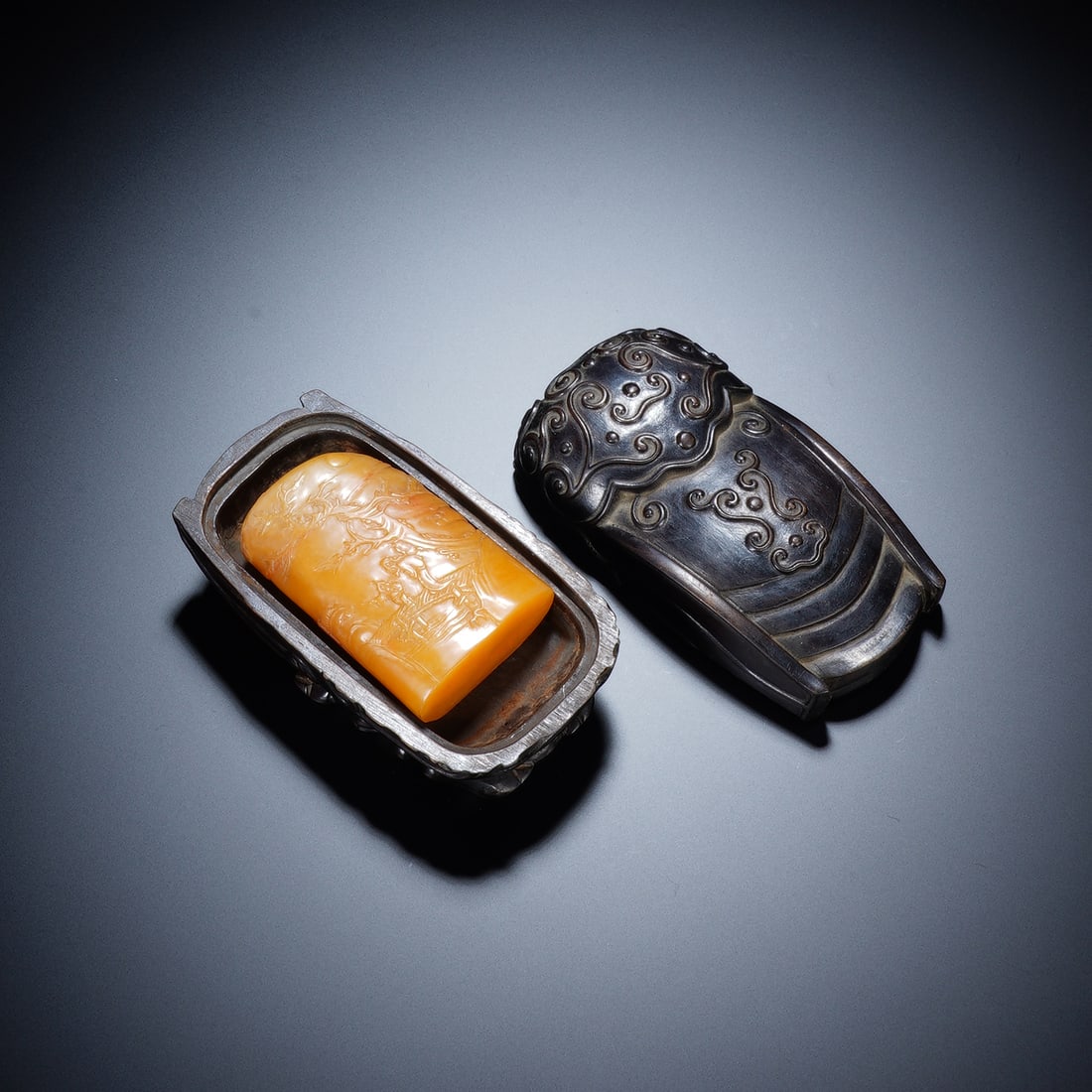 A CHINESE TIANHUANG SEAL AND ZITAN CICADA BOX: Measuring 4 x 2 x 6.2 cm with a total weight of 89 grams, the warm honey-toned Tianhuang seal bears delicate shallow bo yi carvings depicting subtle mountain-and-water landscapes across its smooth pil