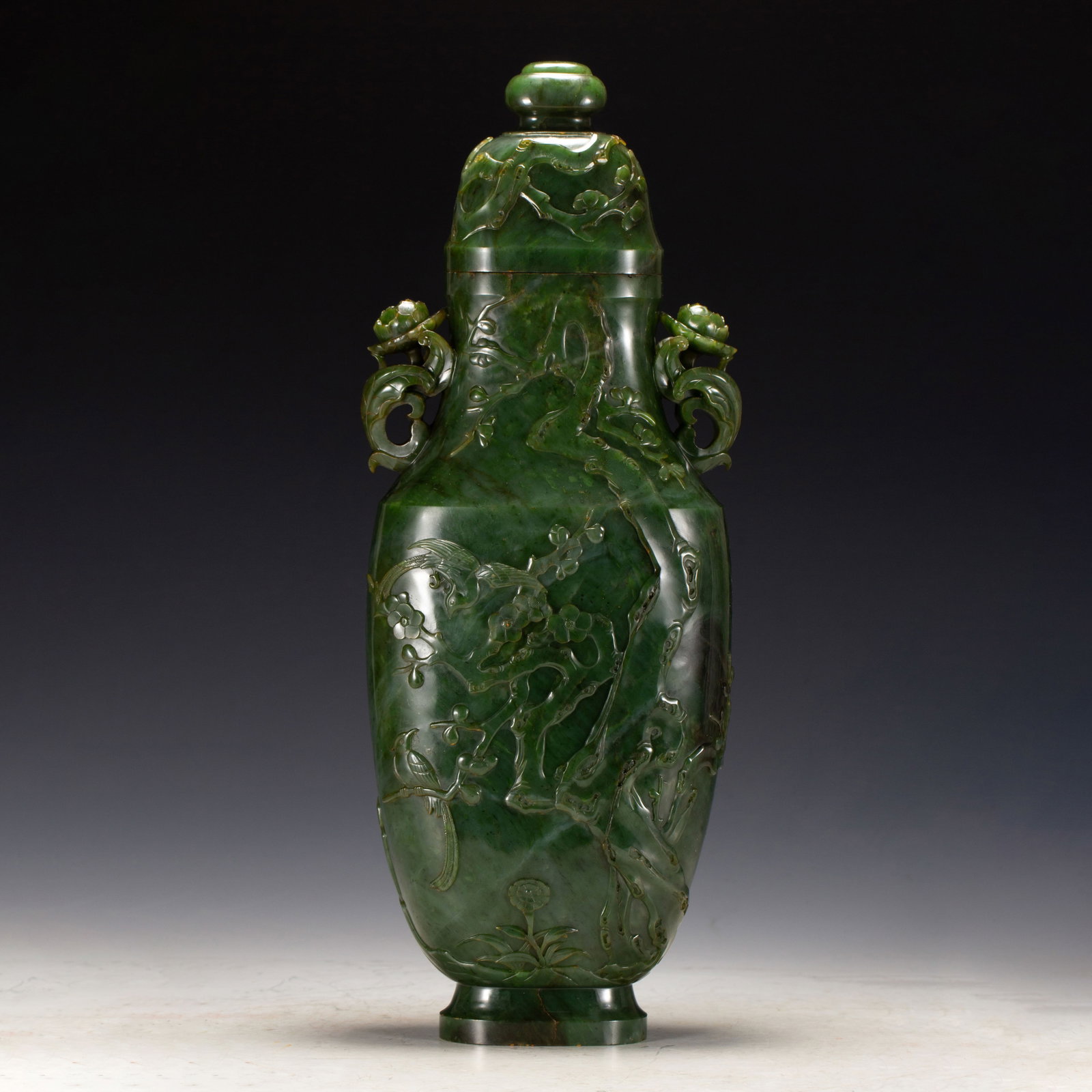 A CHINESE SPINACH JADE LIDDED VASE: Weighing 3320 grams, this elegant vessel measures 16.5 cm in length, 8 cm in width and 42 cm in height. It is finely fashioned from rich spinach jade showcasing natural tonal variegations across its g