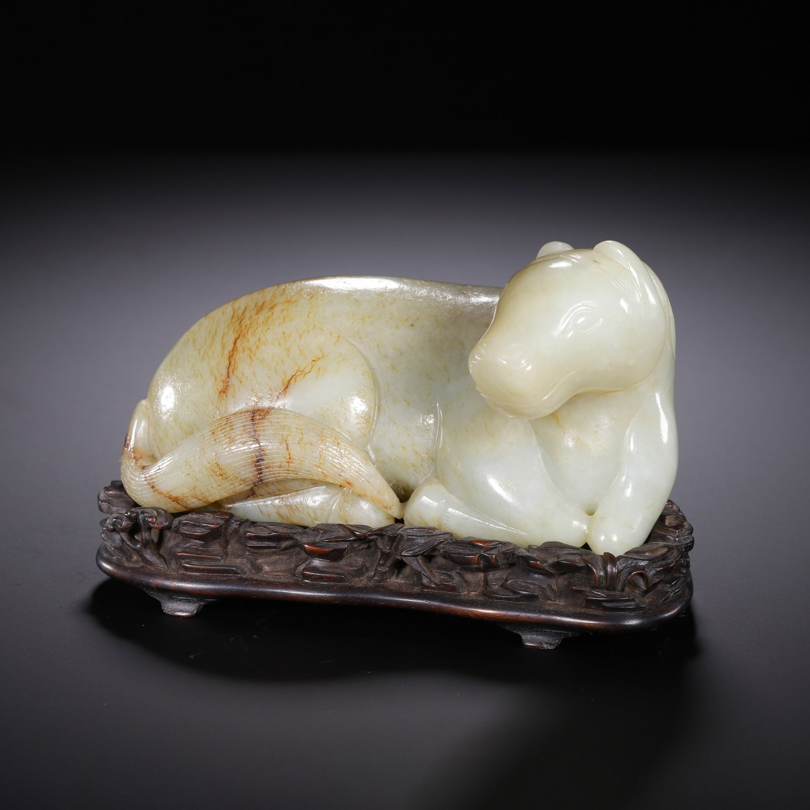 A CHINESE HETIAN RECUMBENT YELLOW JADE HORSE: Weighing 1010 grams, this elegant animal carving measures 14 cm in length, 7.5 cm in width and 10 cm in height. Fashioned from fine Hetian yellow jade, the stone carries soft natural russet streaks