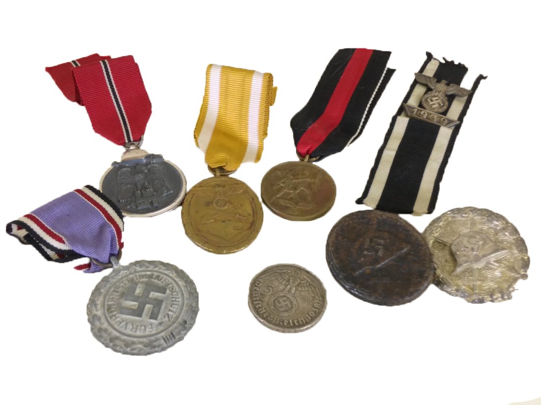 WWII GERMAN MEDALS BADGES AND MORE: Grouping of WWII German items including Sudetenland medal, West Wall medal, Air Defense Honor medal, Eastern Front medal, two Wound badges, Iron Cross spange, and 5 Reich Mark coin.