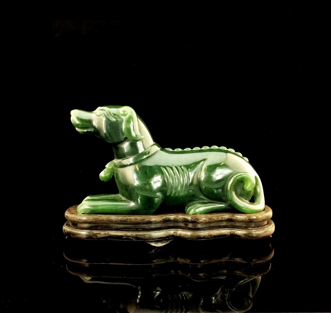 FINE CARVED GREEN SPINACH JADE RECUMBENT DOG W/ STAND: Chinese Green Spinach Jade of Dog. Smoothly carved green spinach jade resembled a symbolic of Chinese horoscope year of dog. Head Facing straight, banded on neck, laying on four legs, with circled tai